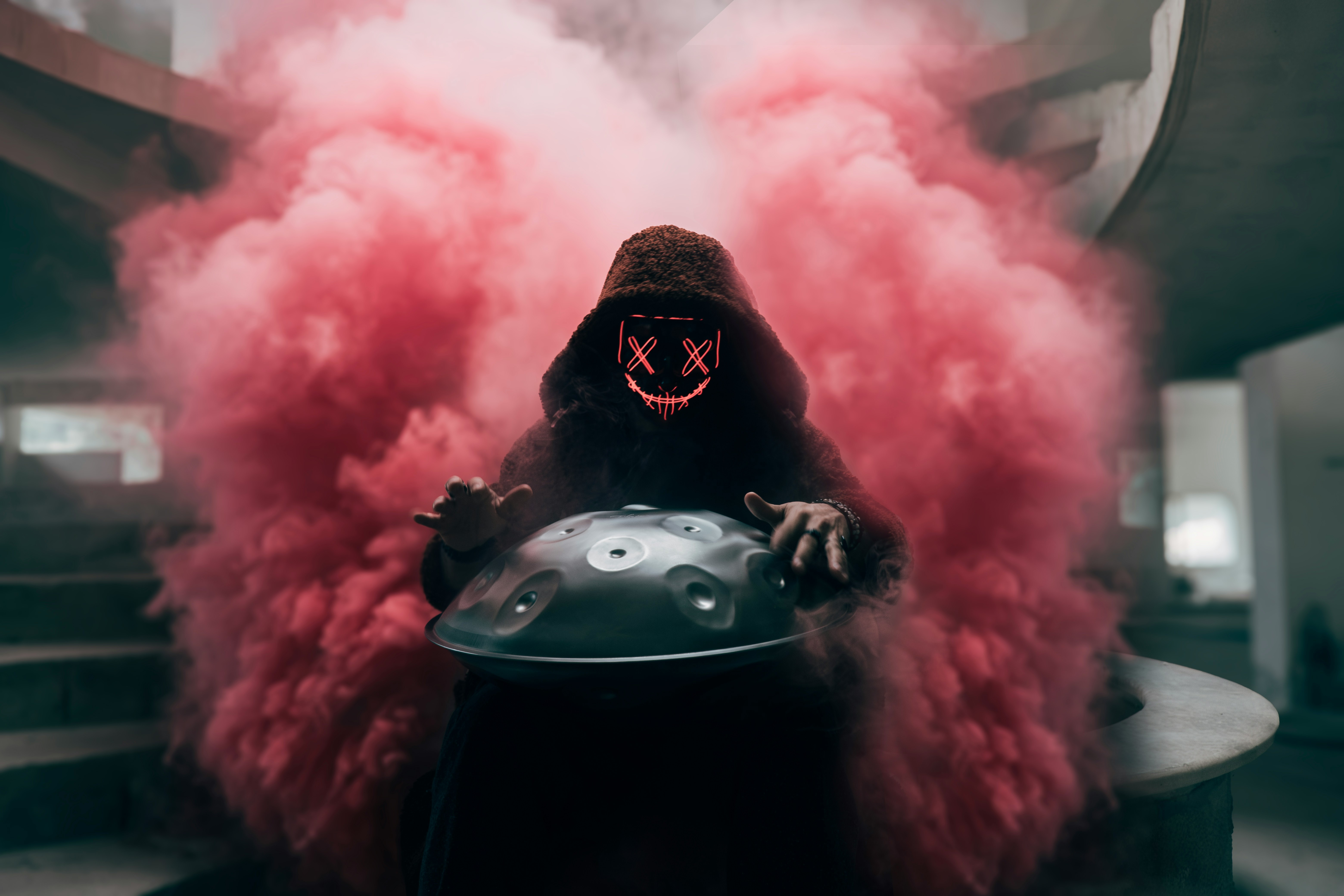 Person in a mask playing a handpan with pink smoke HD Wallpaper