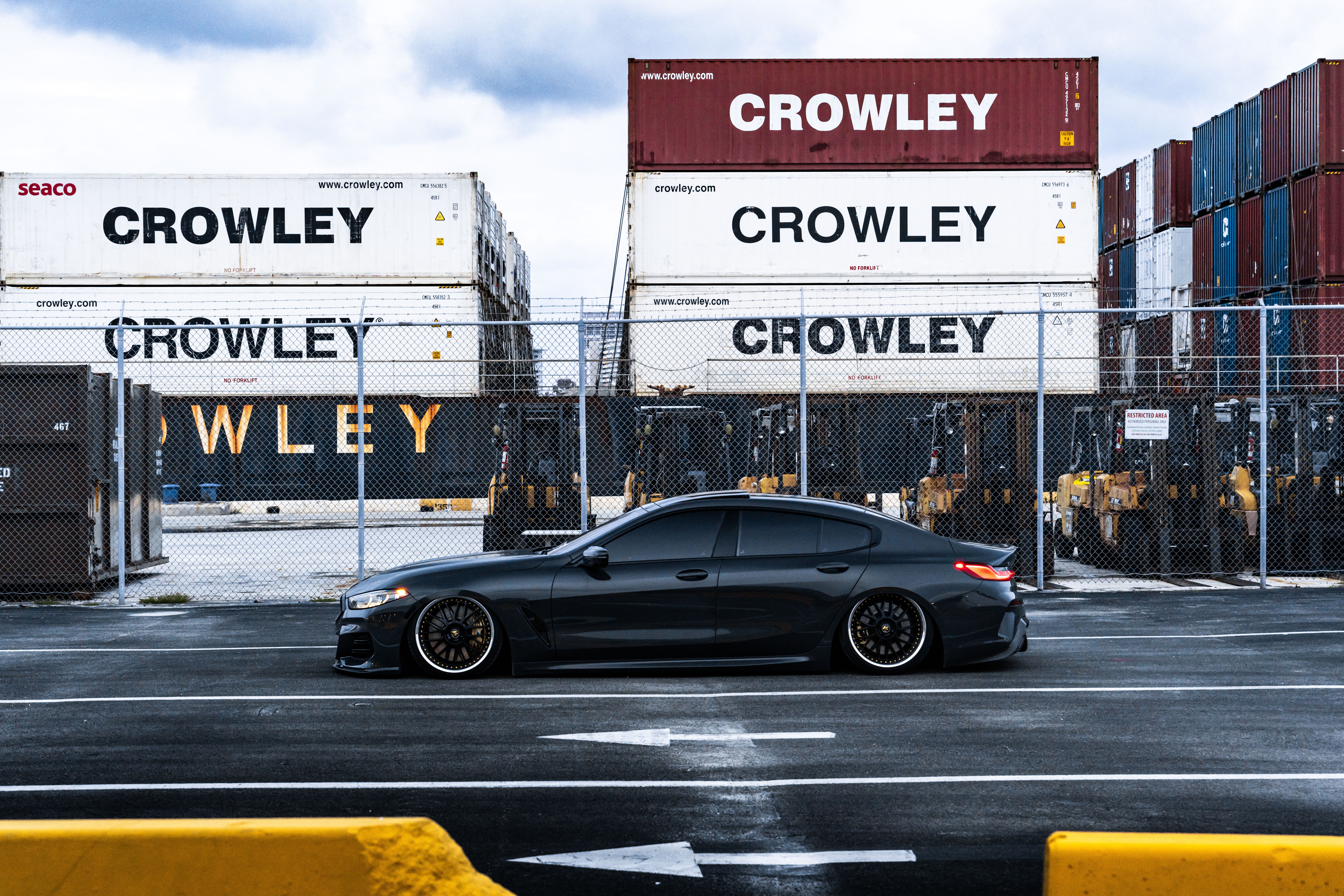 Black BMW 850i parked at a shipping yard HD Wallpaper