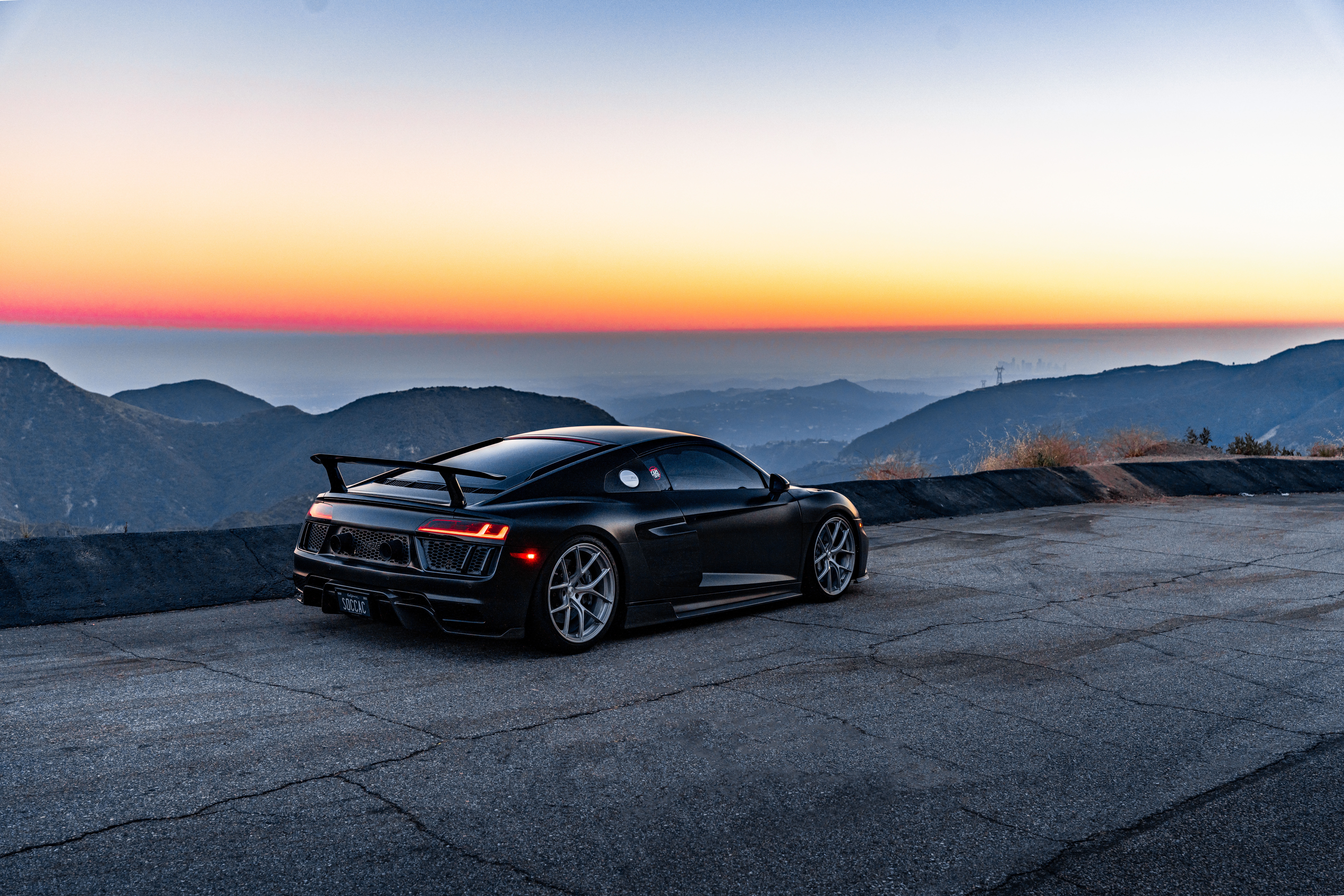 Black Audi R8 V10 on a mountain road at sunset HD Wallpaper