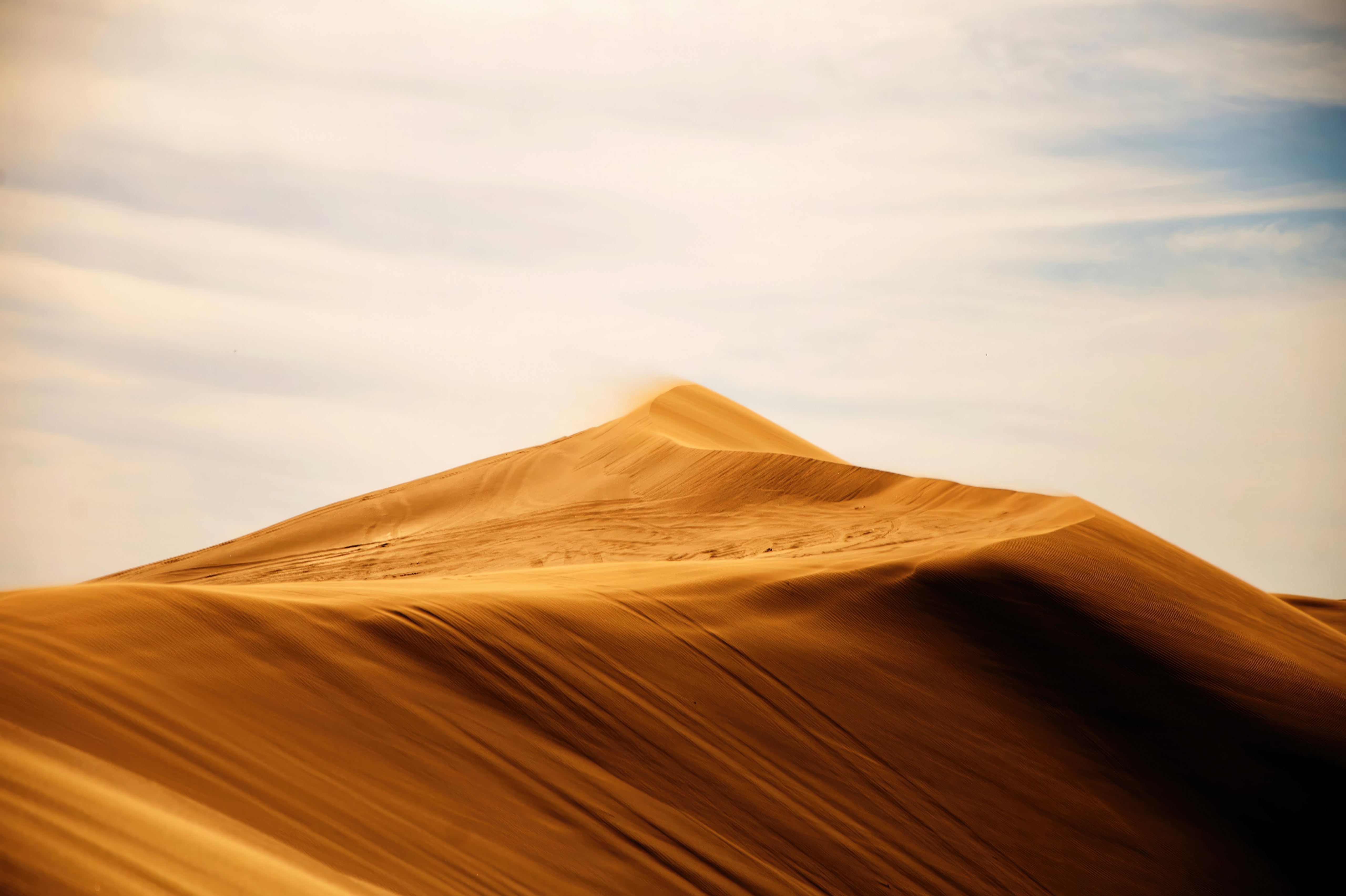 Desert sand dunes under a cloudy sky HD Wallpaper