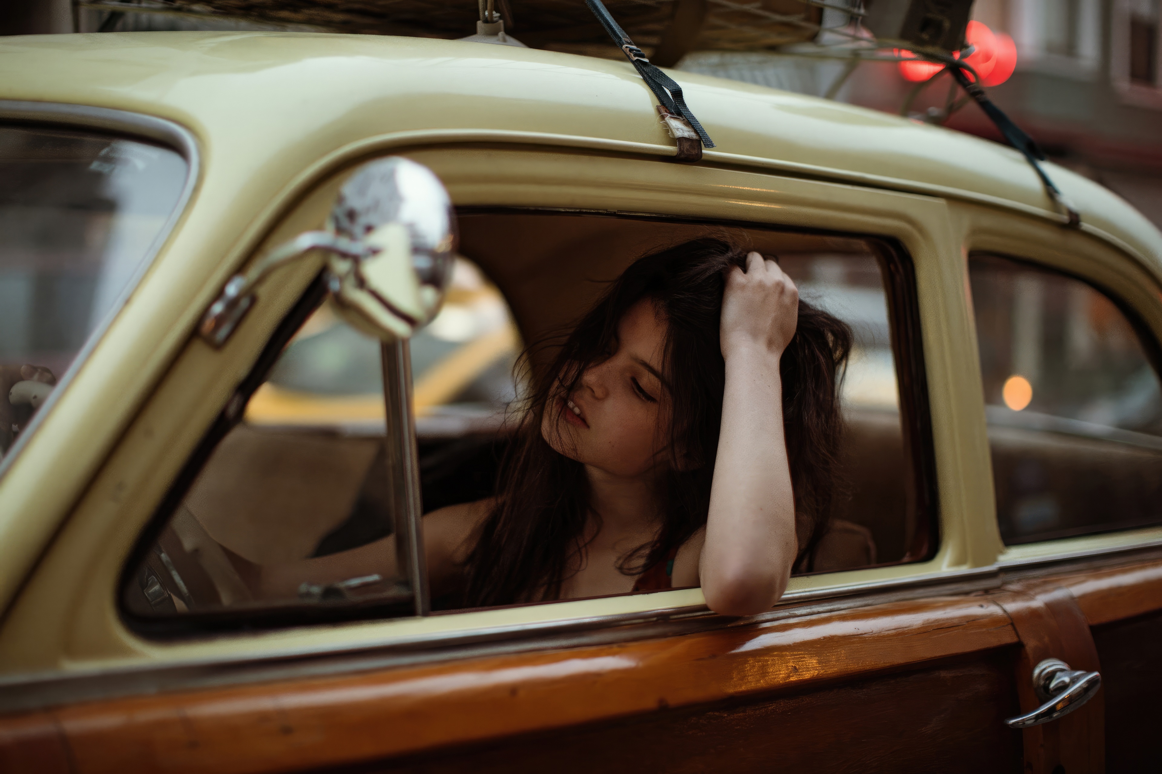Girl in vintage car with luggage on roof HD Wallpaper