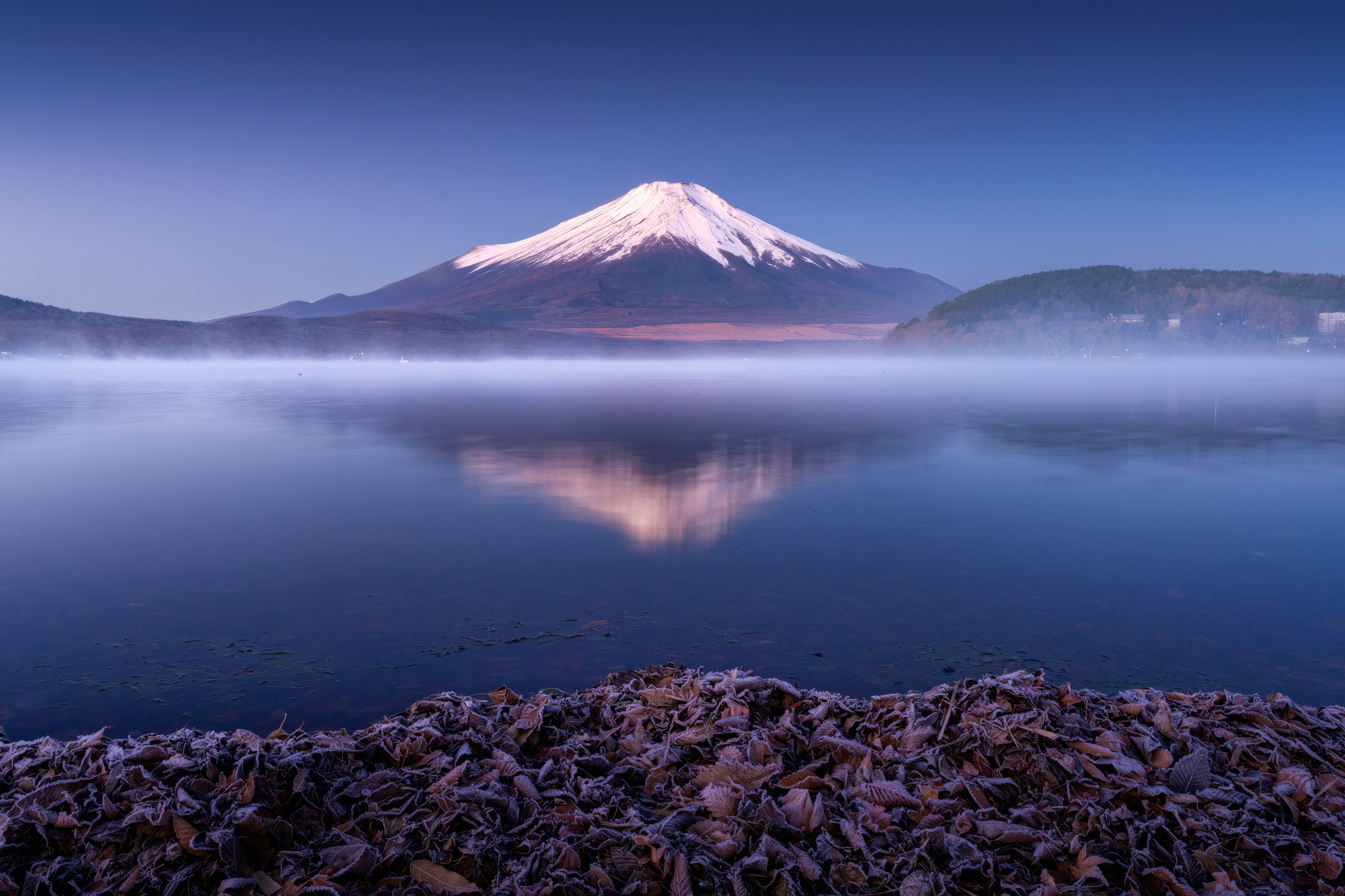 Mount Fuji reflected in a misty lake at dawn HD Wallpaper