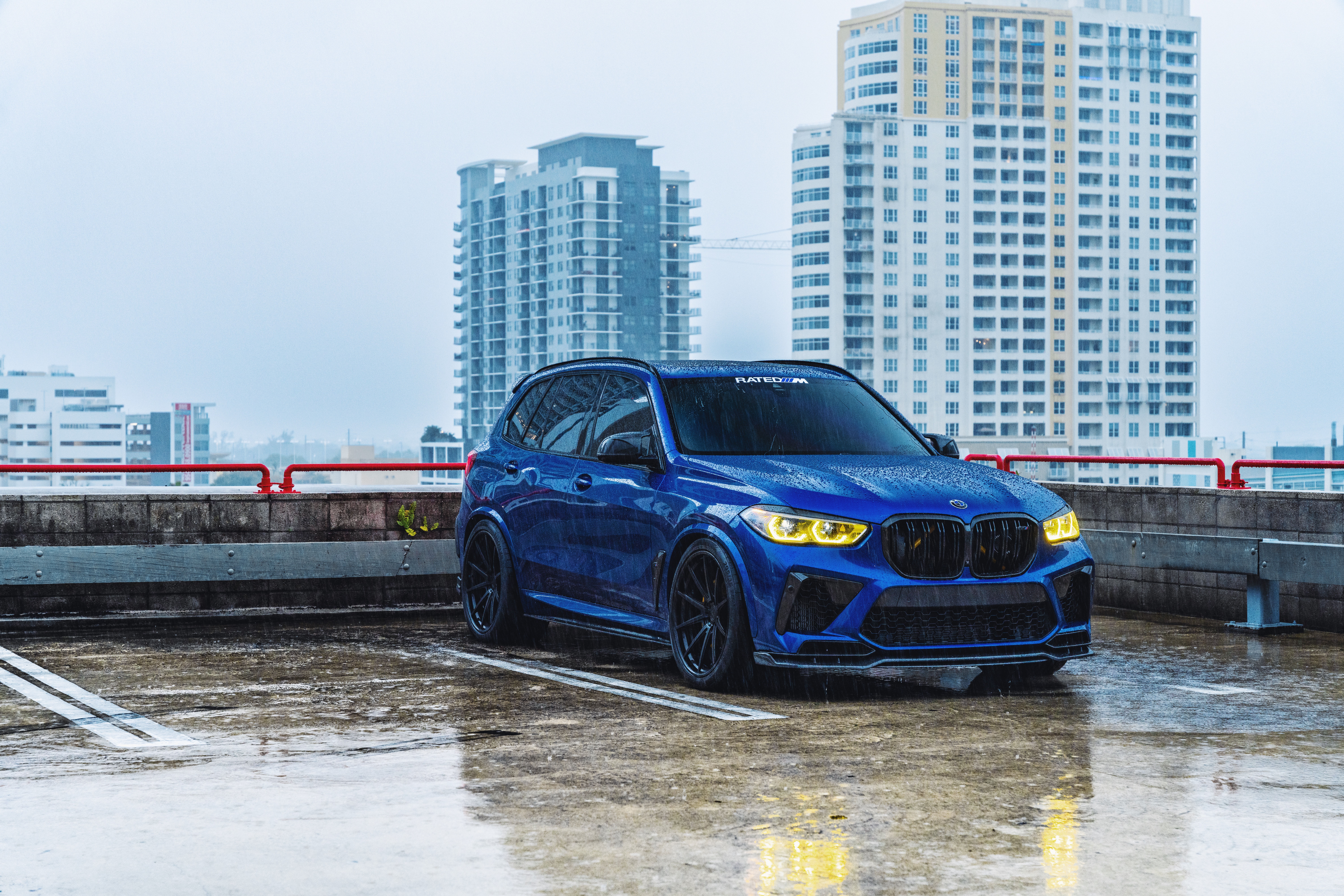 Blue BMW X5M parked on a wet rooftop HD Wallpaper