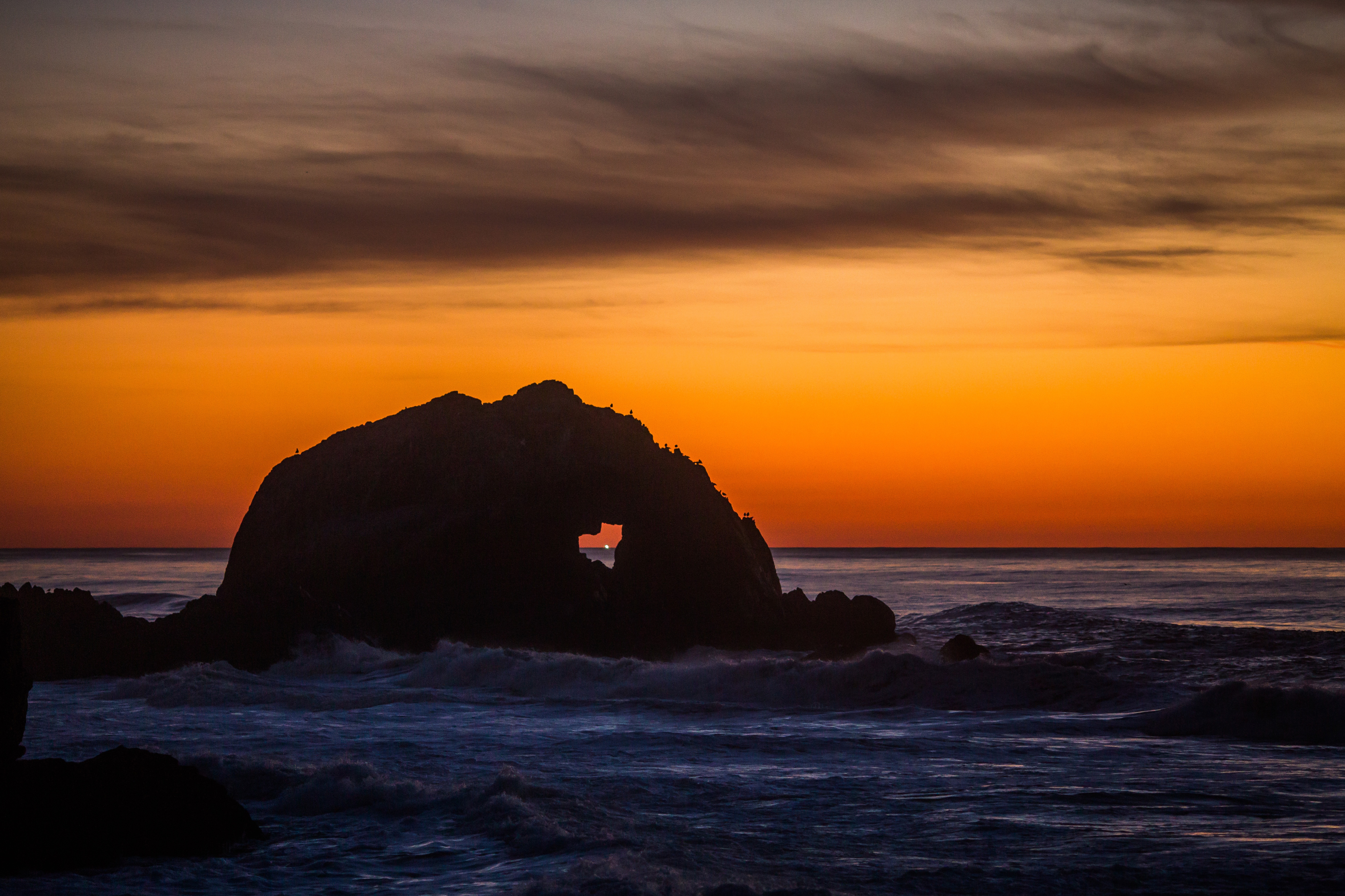 Sunset over the ocean with a rock arch HD Wallpaper