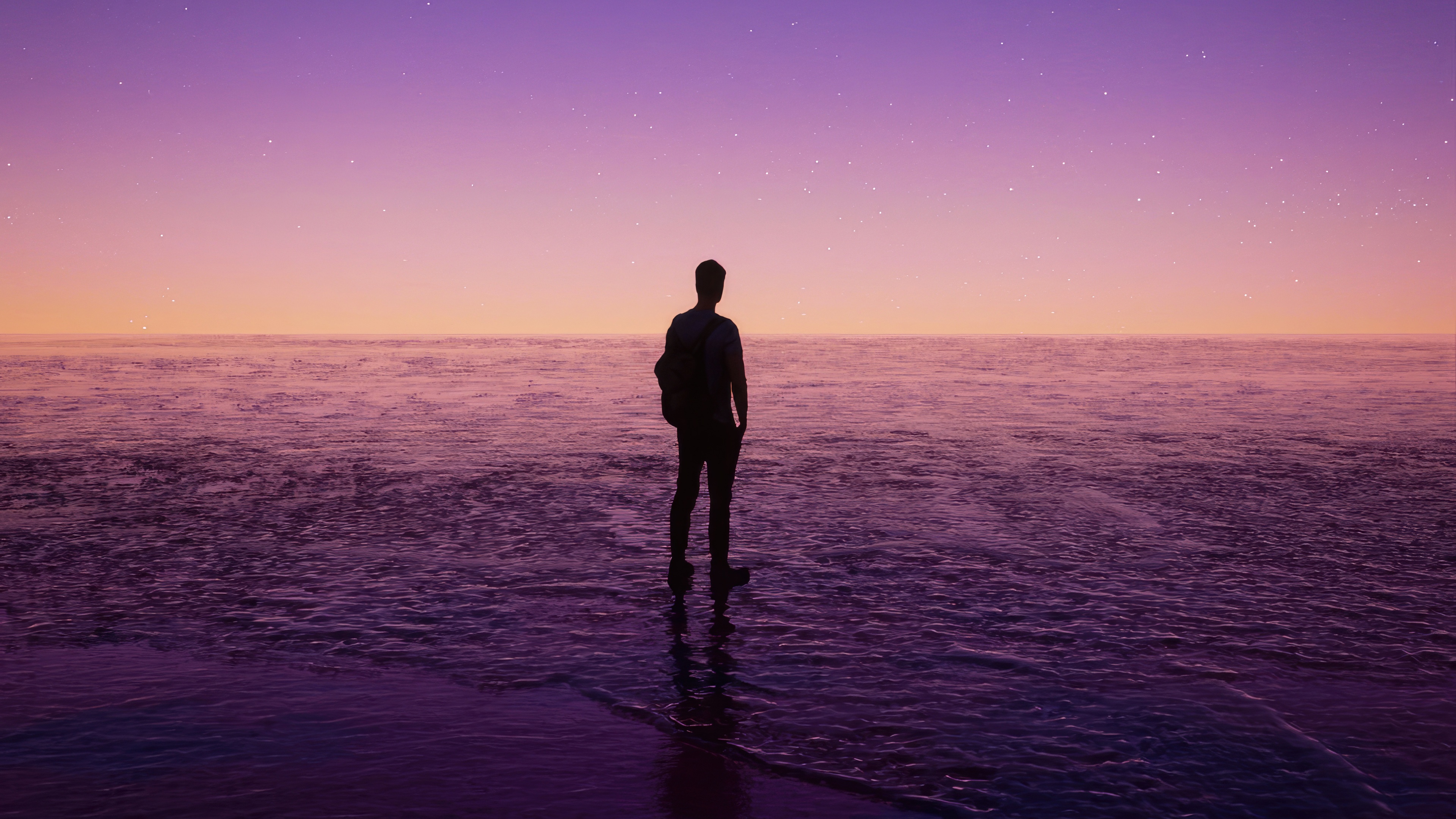 Silhouette of a person standing in the ocean at sunset HD Wallpaper