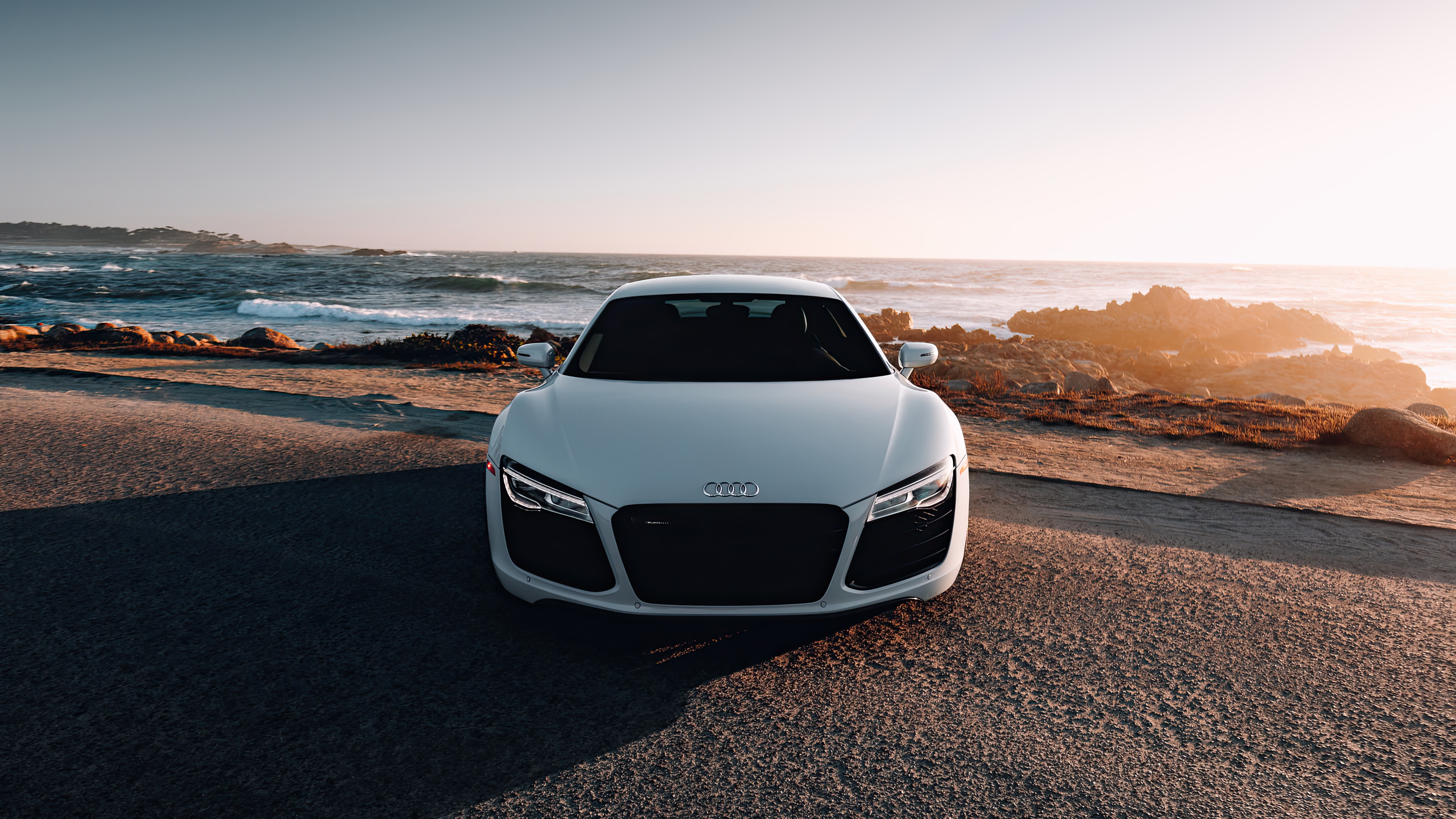 White Audi R8 parked by the ocean at sunset HD Wallpaper