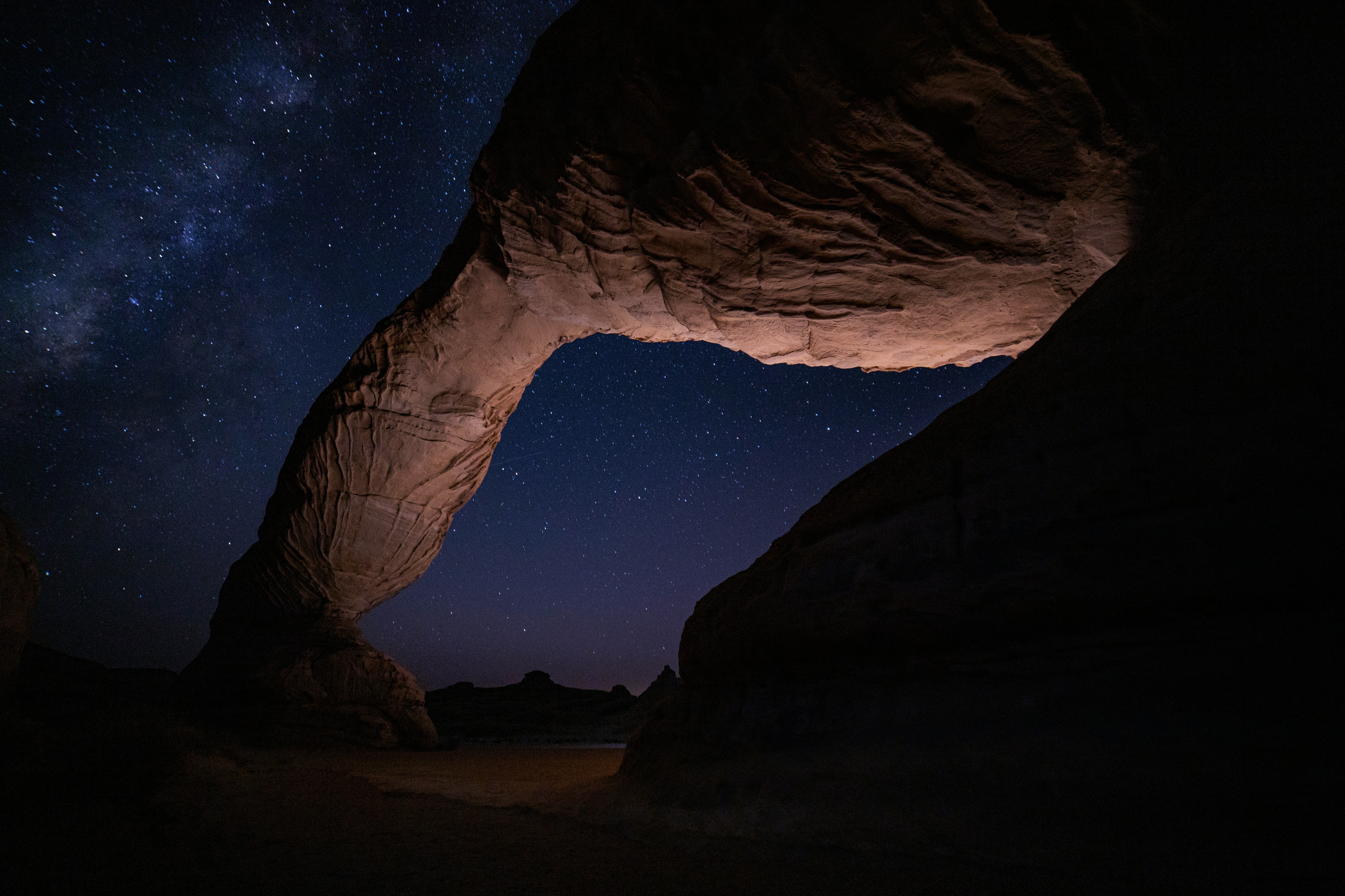 Rock formation under a starry night sky HD Wallpaper