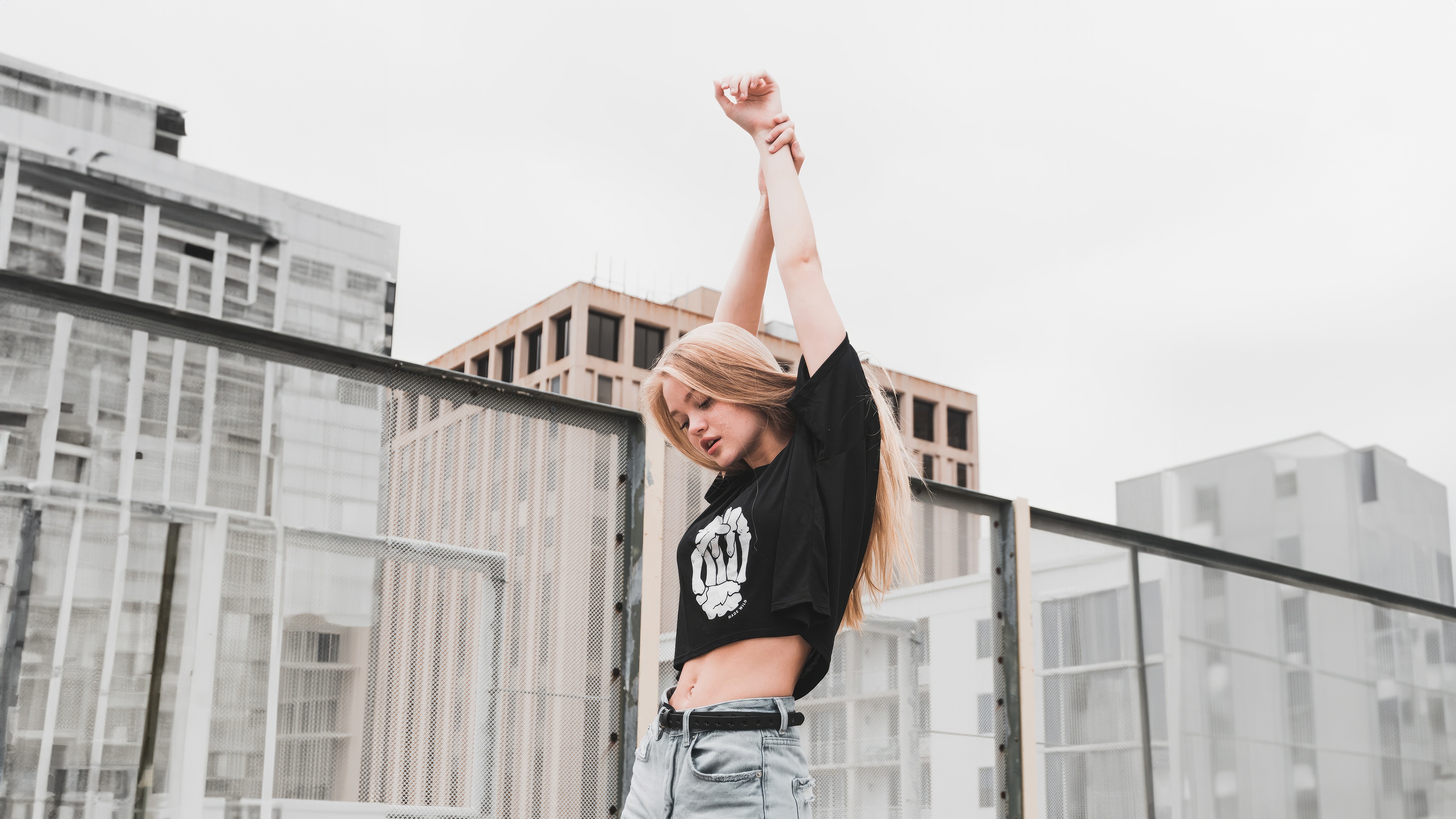 Girl with arms raised on a rooftop HD Wallpaper