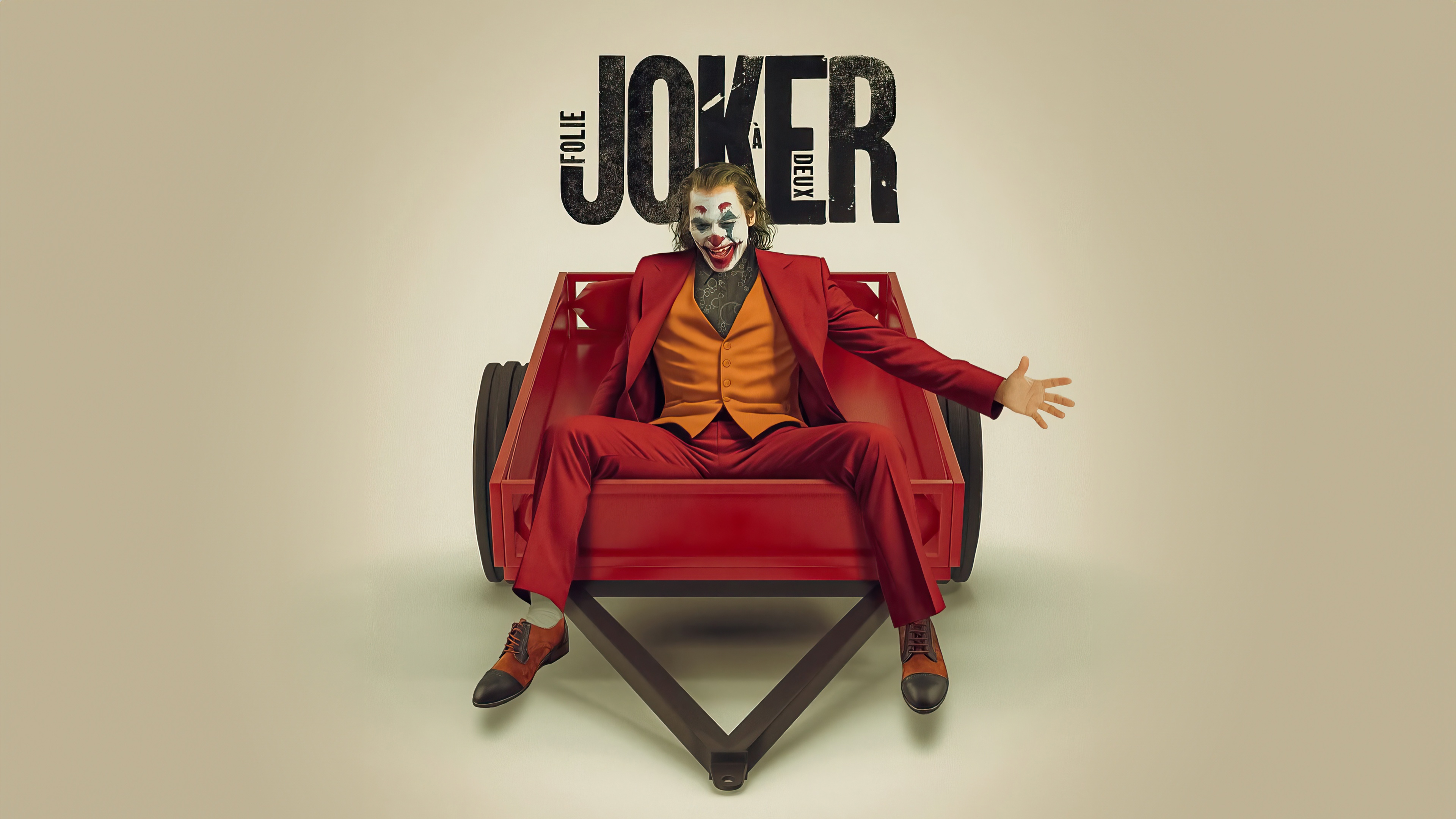 Joker sitting in a red cart with "Folie à Deux" title HD Wallpaper