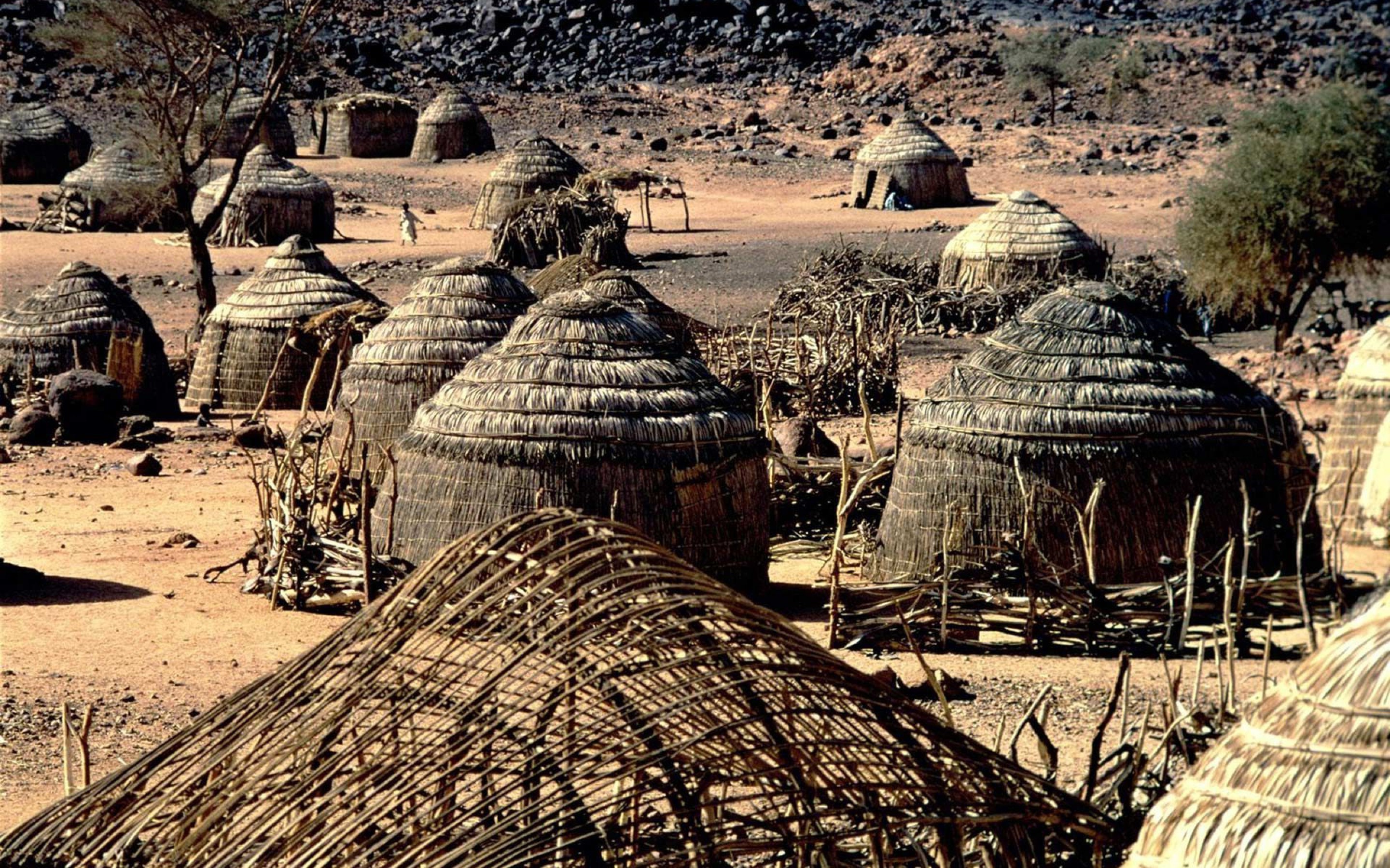 African village with thatched huts in a dry landscape HD Wallpaper