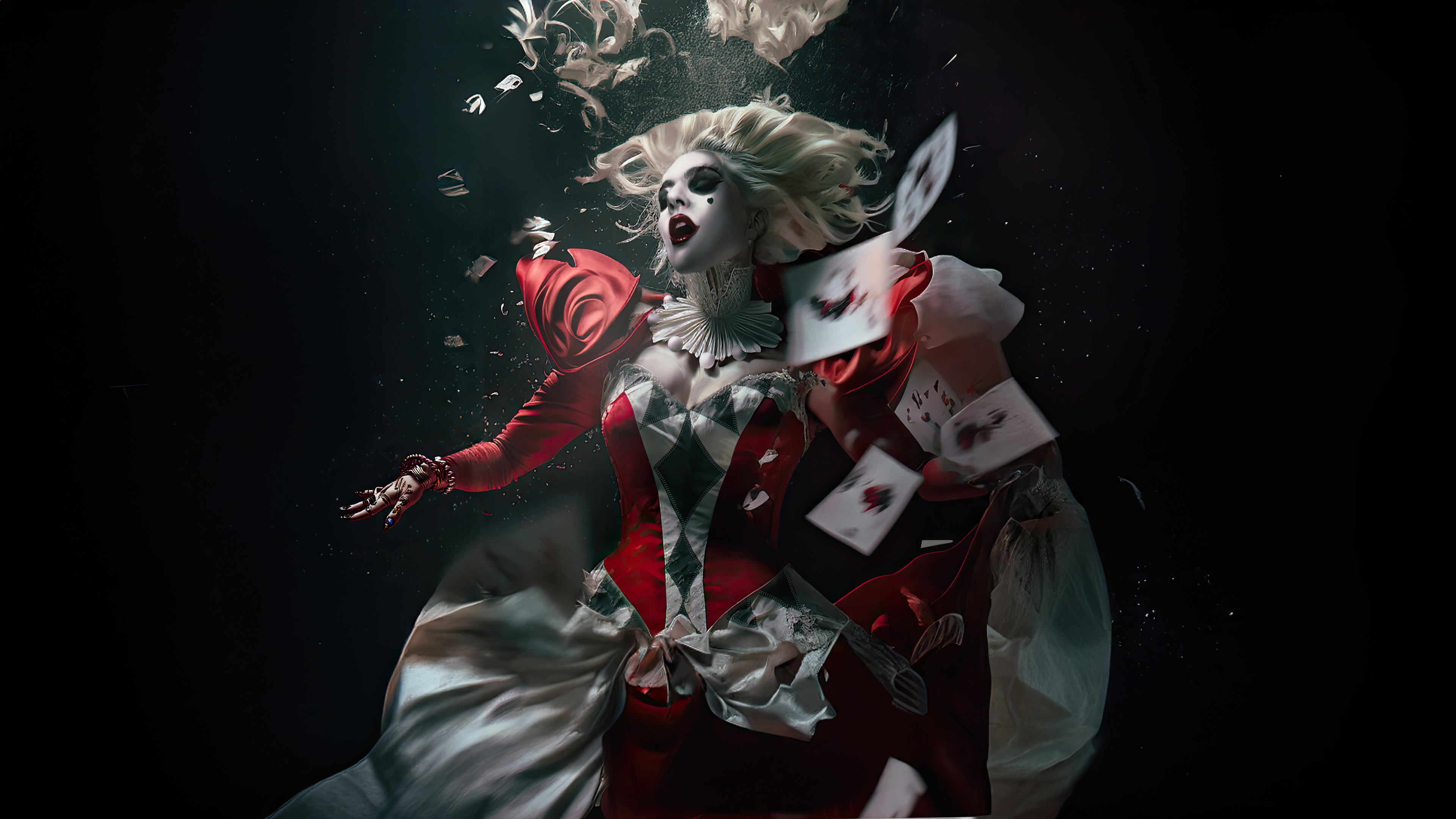 Harley Quinn in a red and white jester costume underwater HD Wallpaper