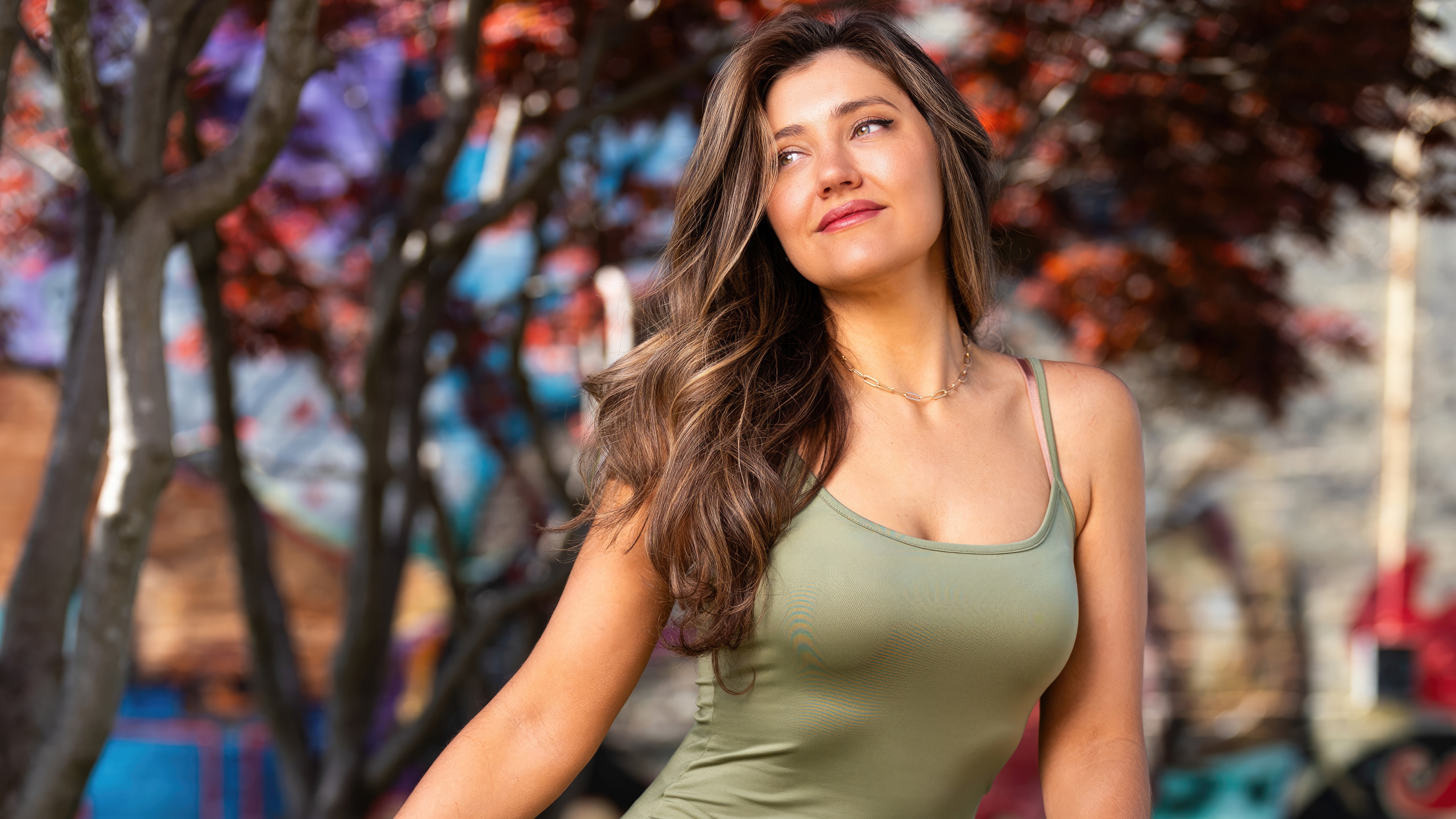 Woman in green tank top with colorful mural background HD Wallpaper