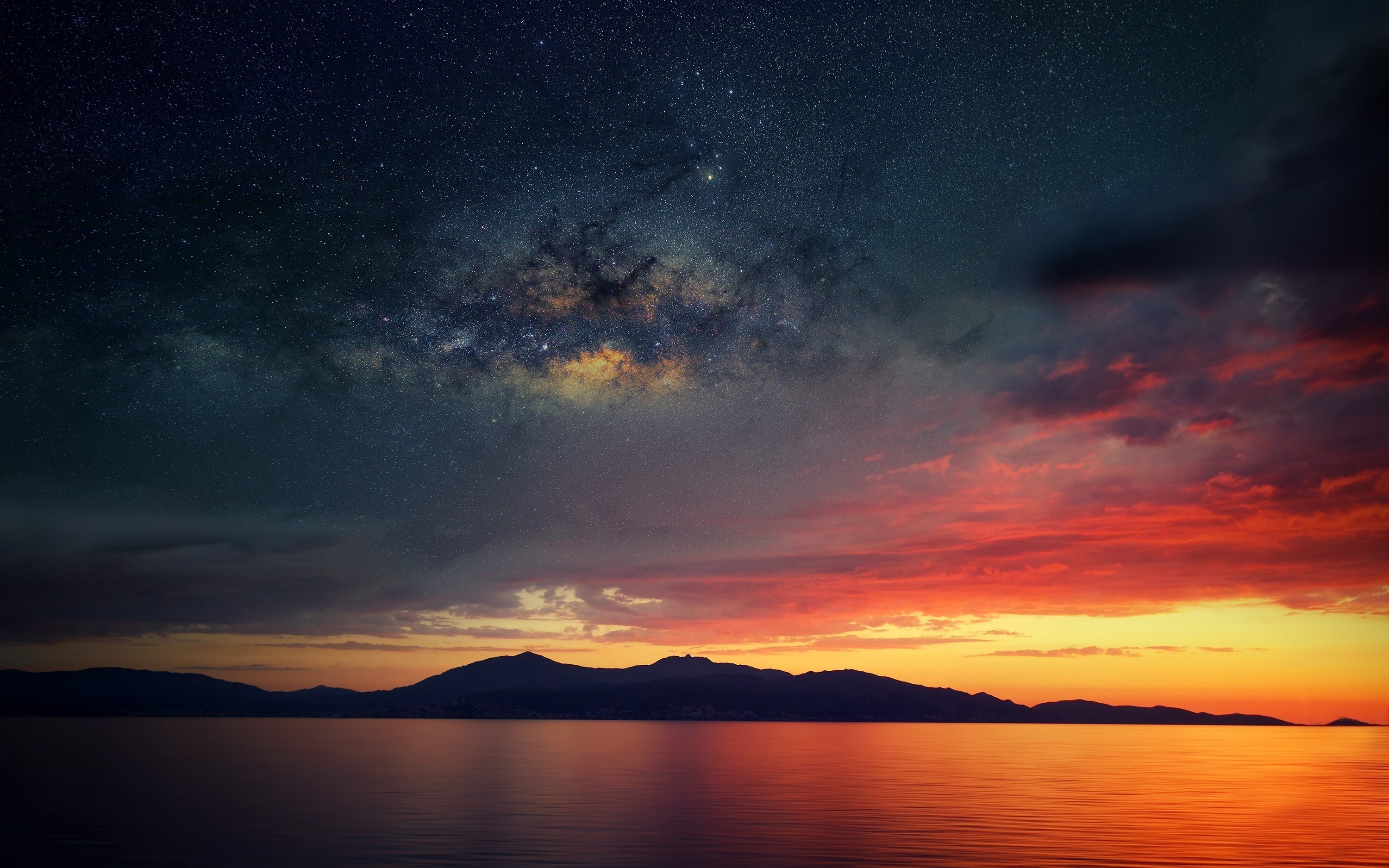 Milky Way over calm sea and mountains at sunset HD Wallpaper