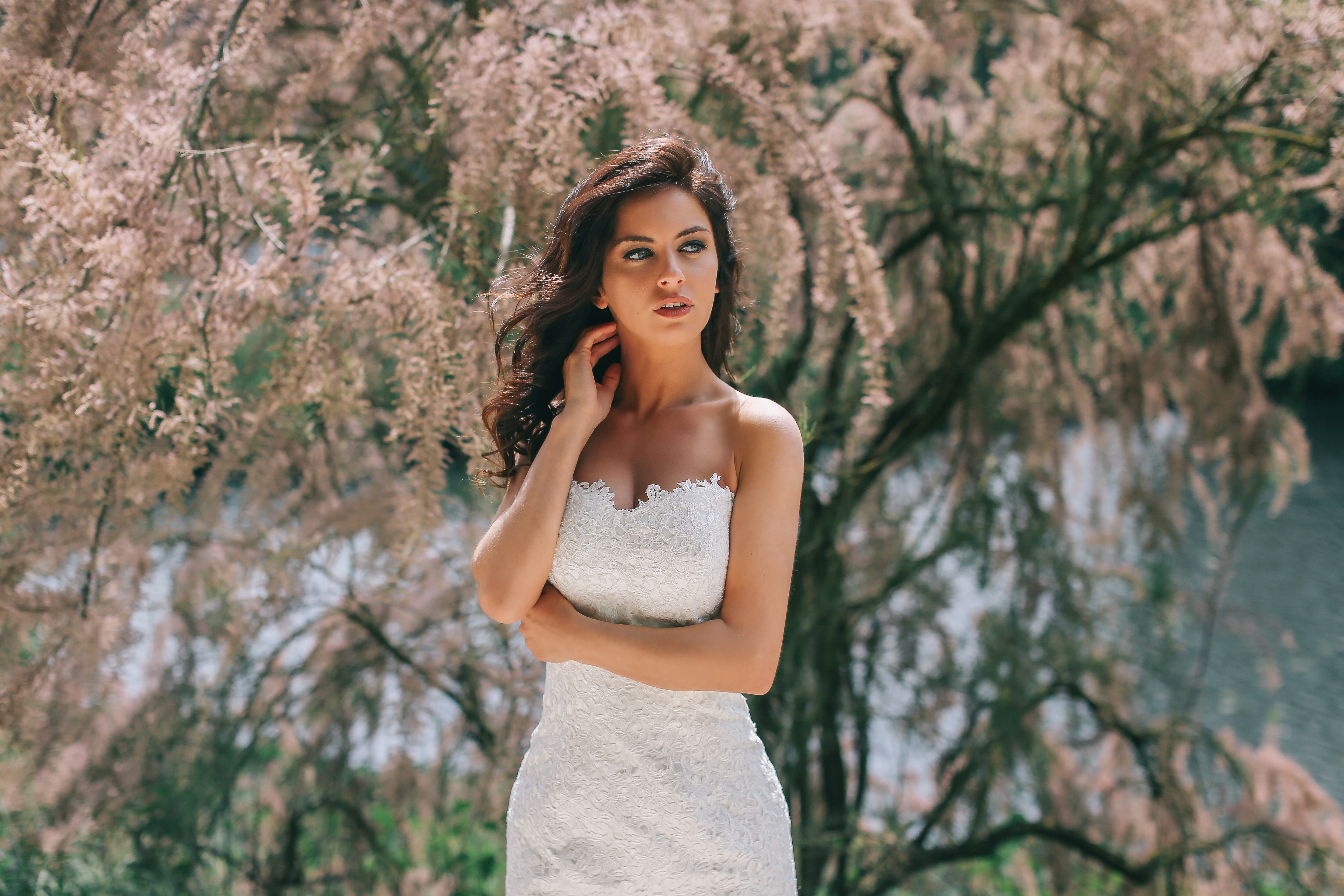Bride in a white lace dress posing outdoors HD Wallpaper