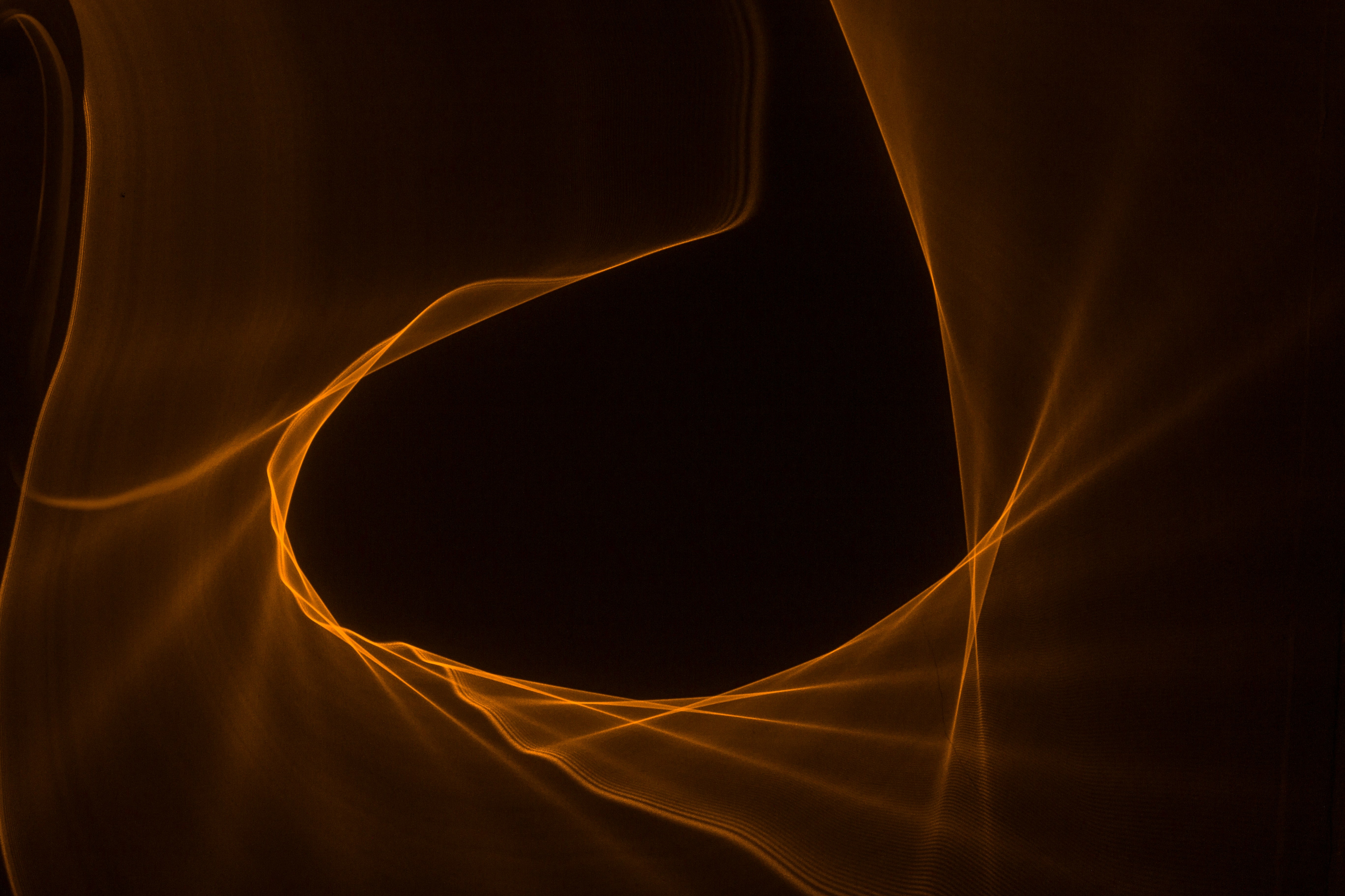 Orange light trails forming a circular shape HD Wallpaper
