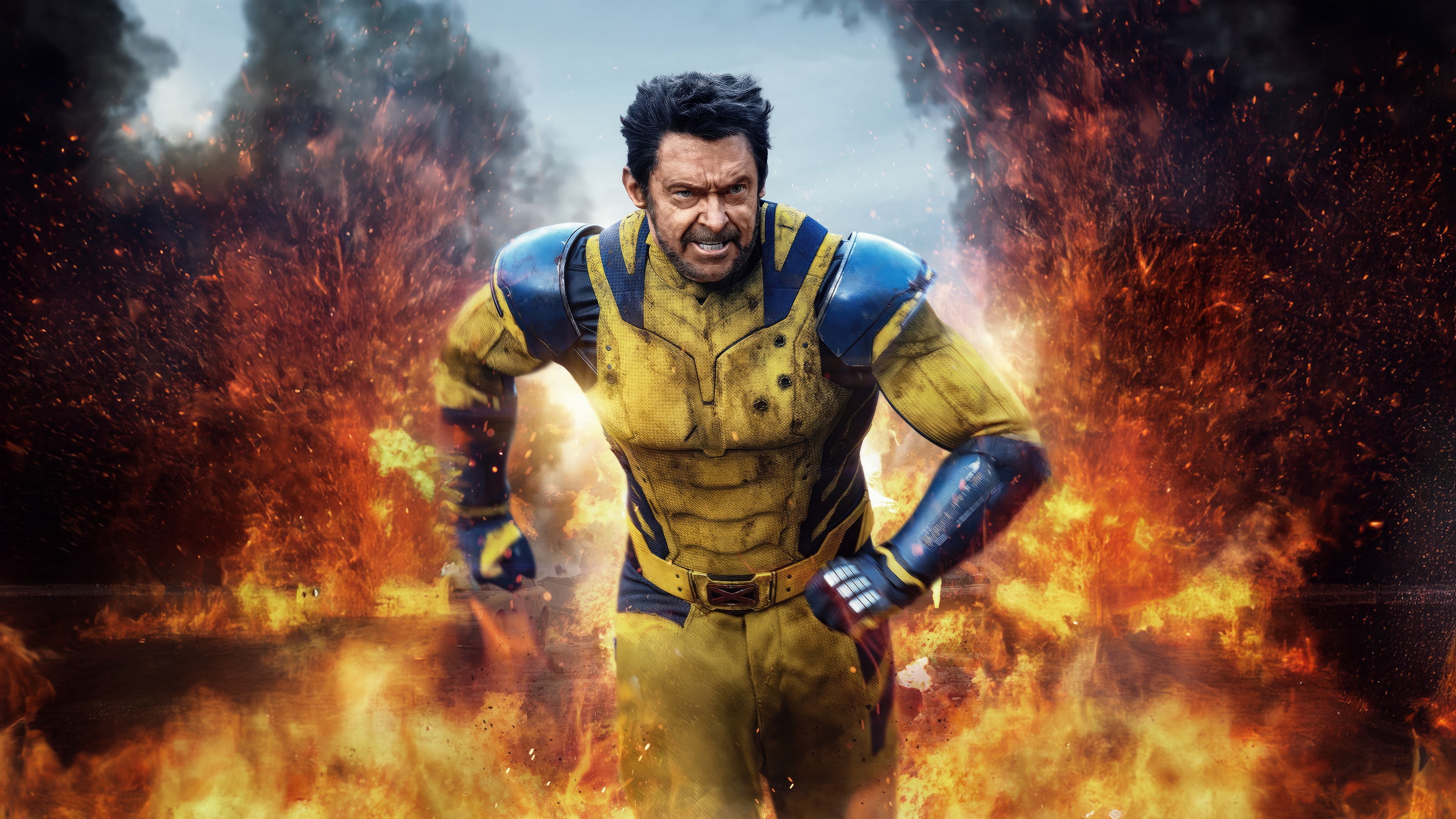Wolverine in a yellow and blue suit surrounded by fire HD Wallpaper