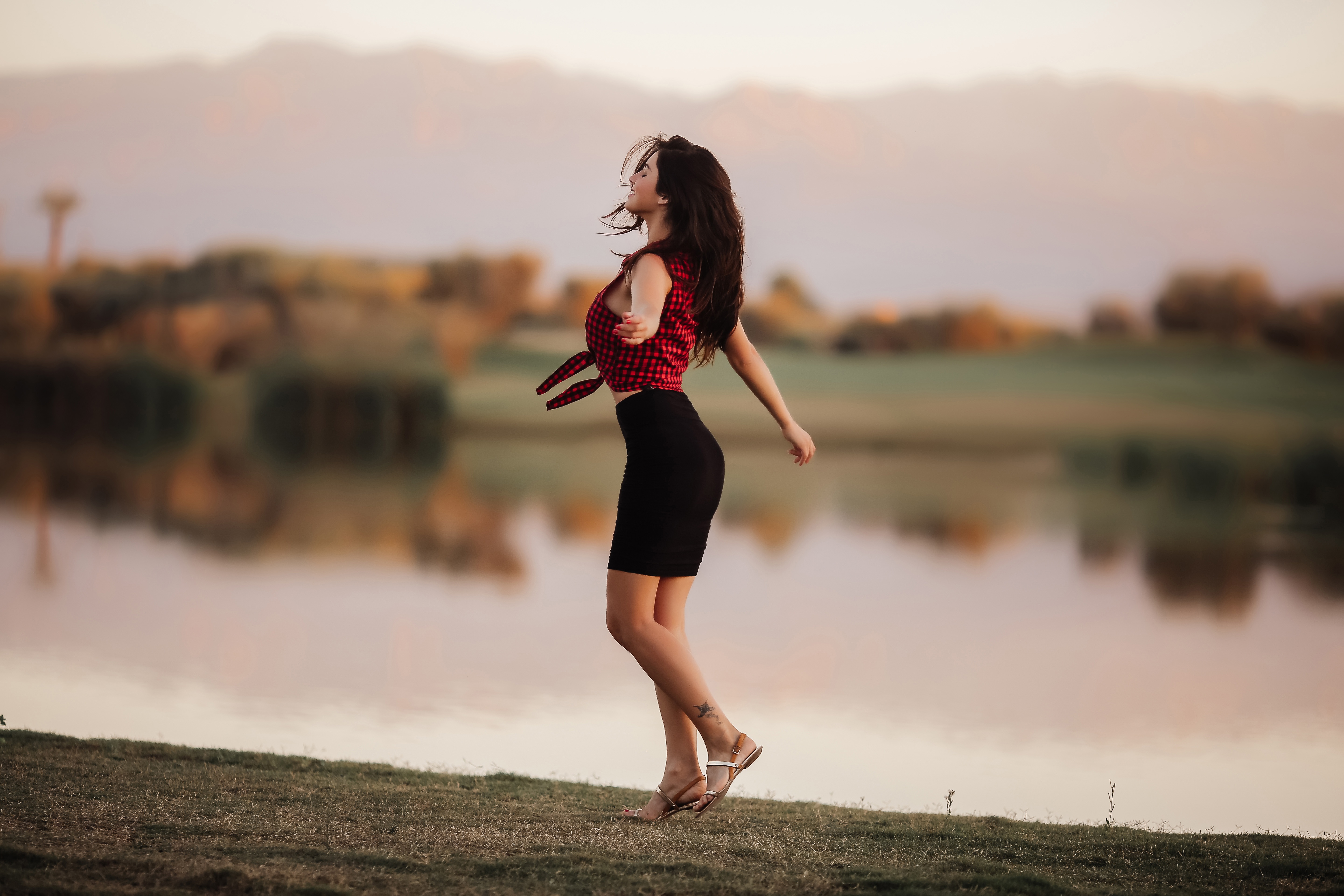 Woman dancing by a lake at sunset HD Wallpaper