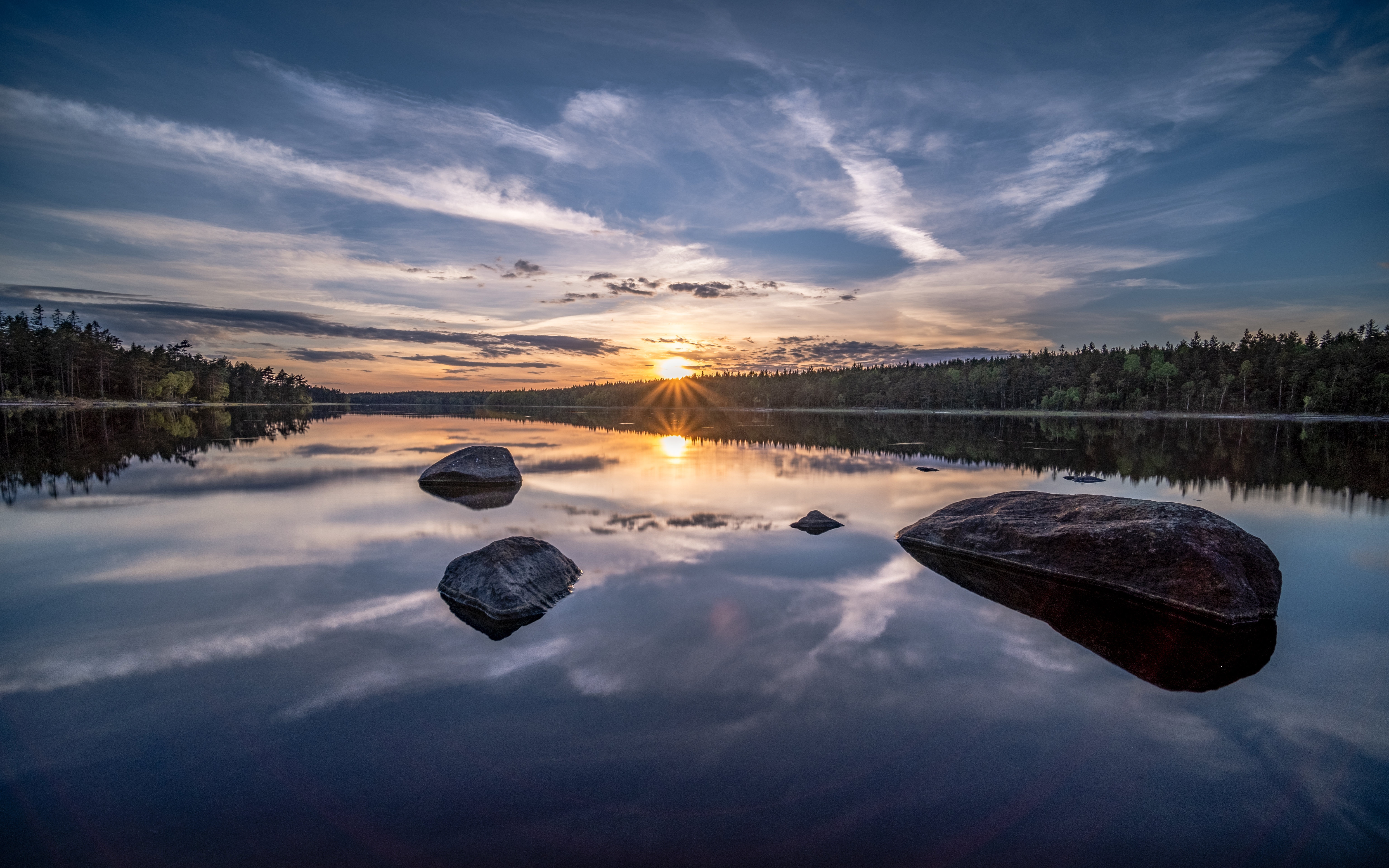 Sunset over a calm lake with rocks and forest HD Wallpaper
