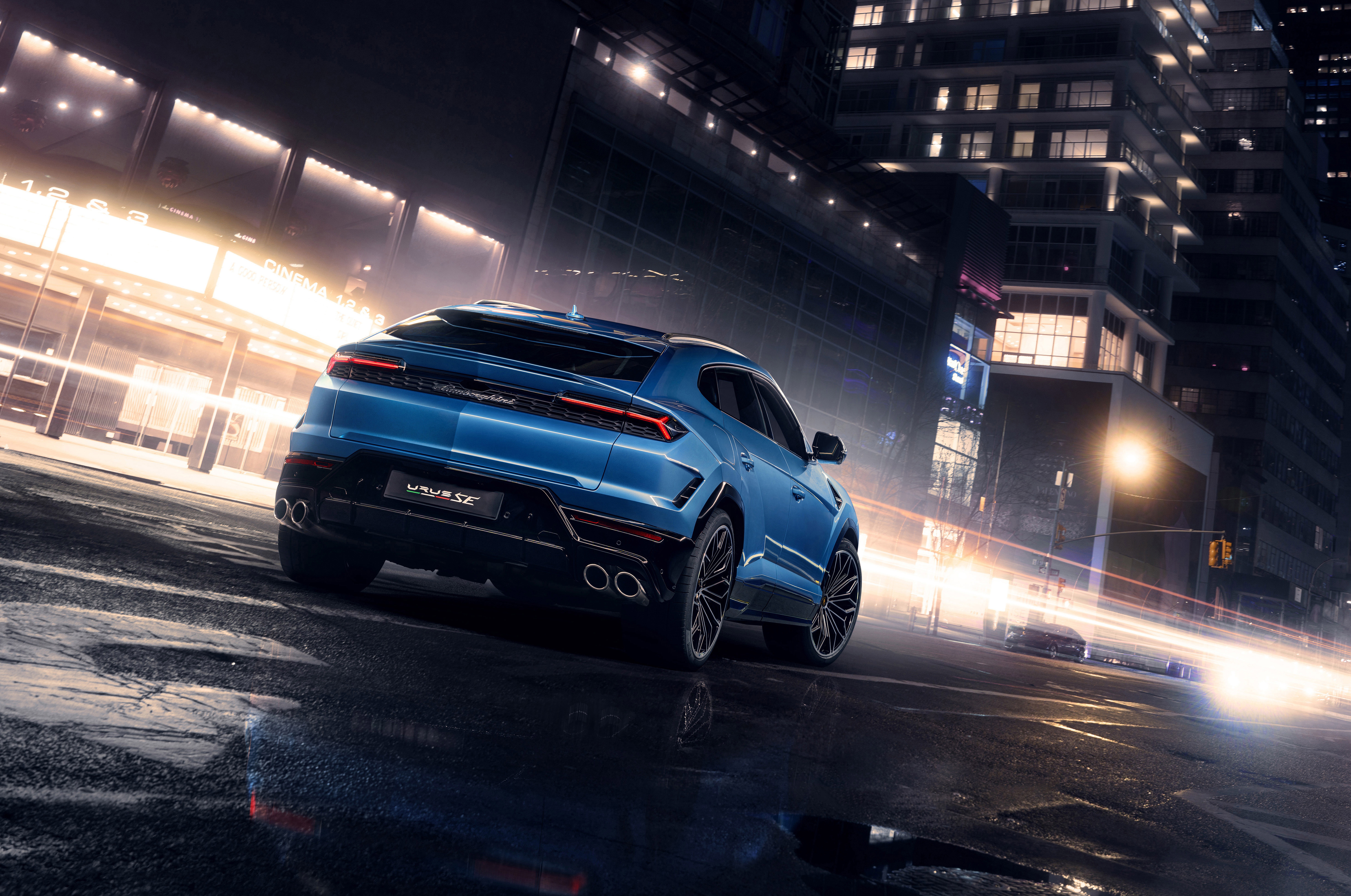 Blue Lamborghini Urus SE 2024 SUV on wet city street at night HD Wallpaper