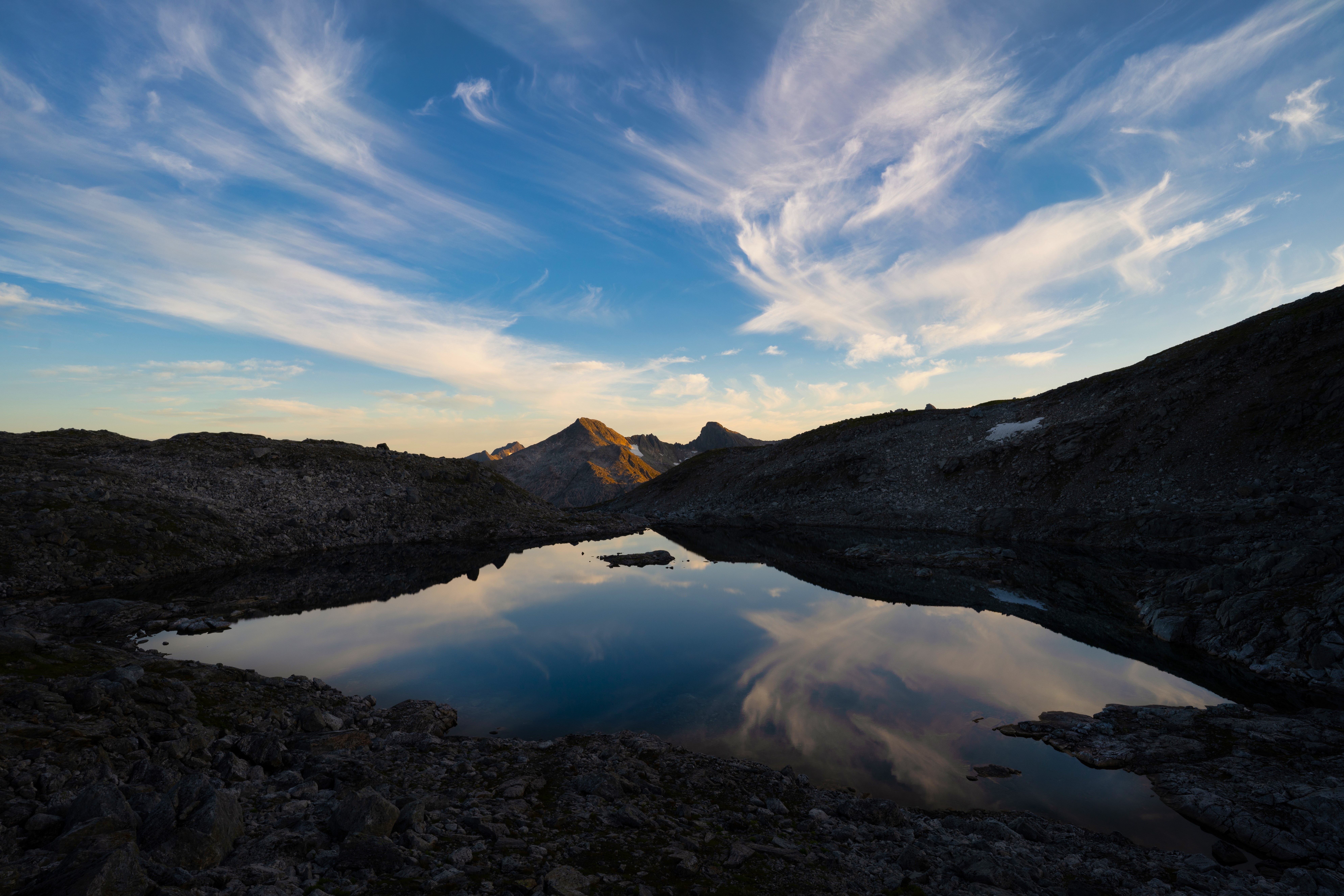 Mountain lake reflecting wispy clouds at sunset HD Wallpaper