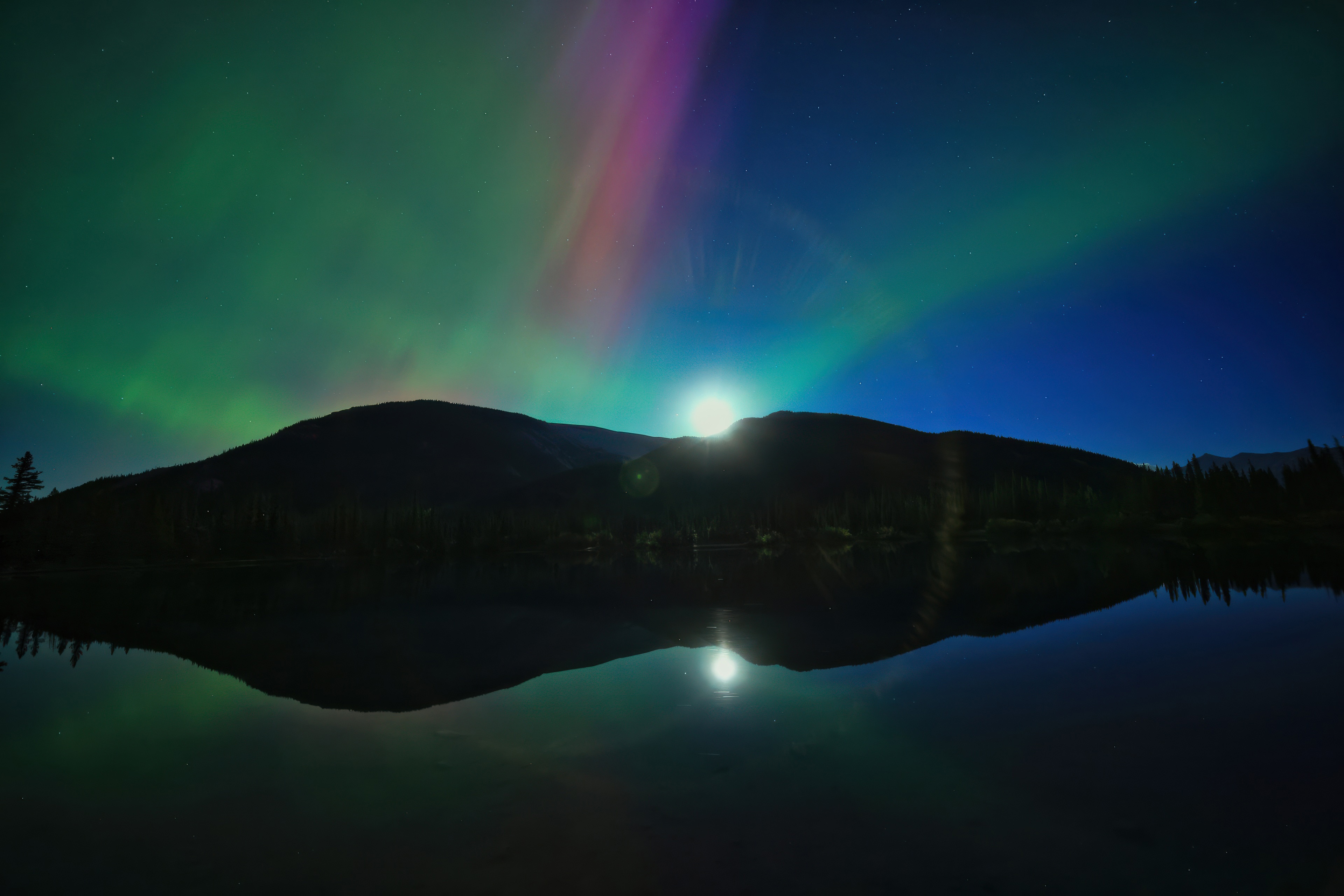 Aurora over mountains reflected in a lake HD Wallpaper