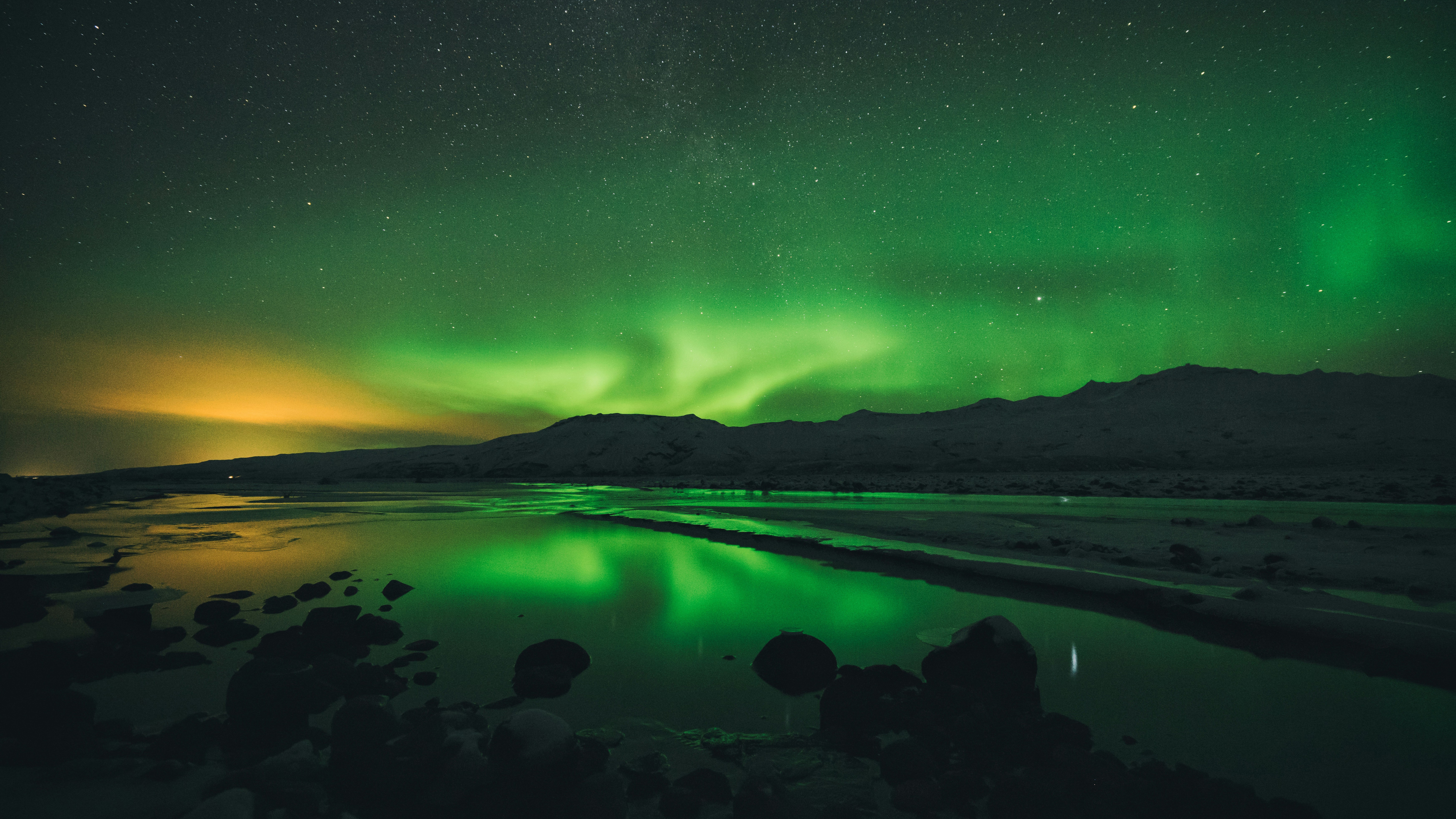 Northern Lights over a calm body of water HD Wallpaper