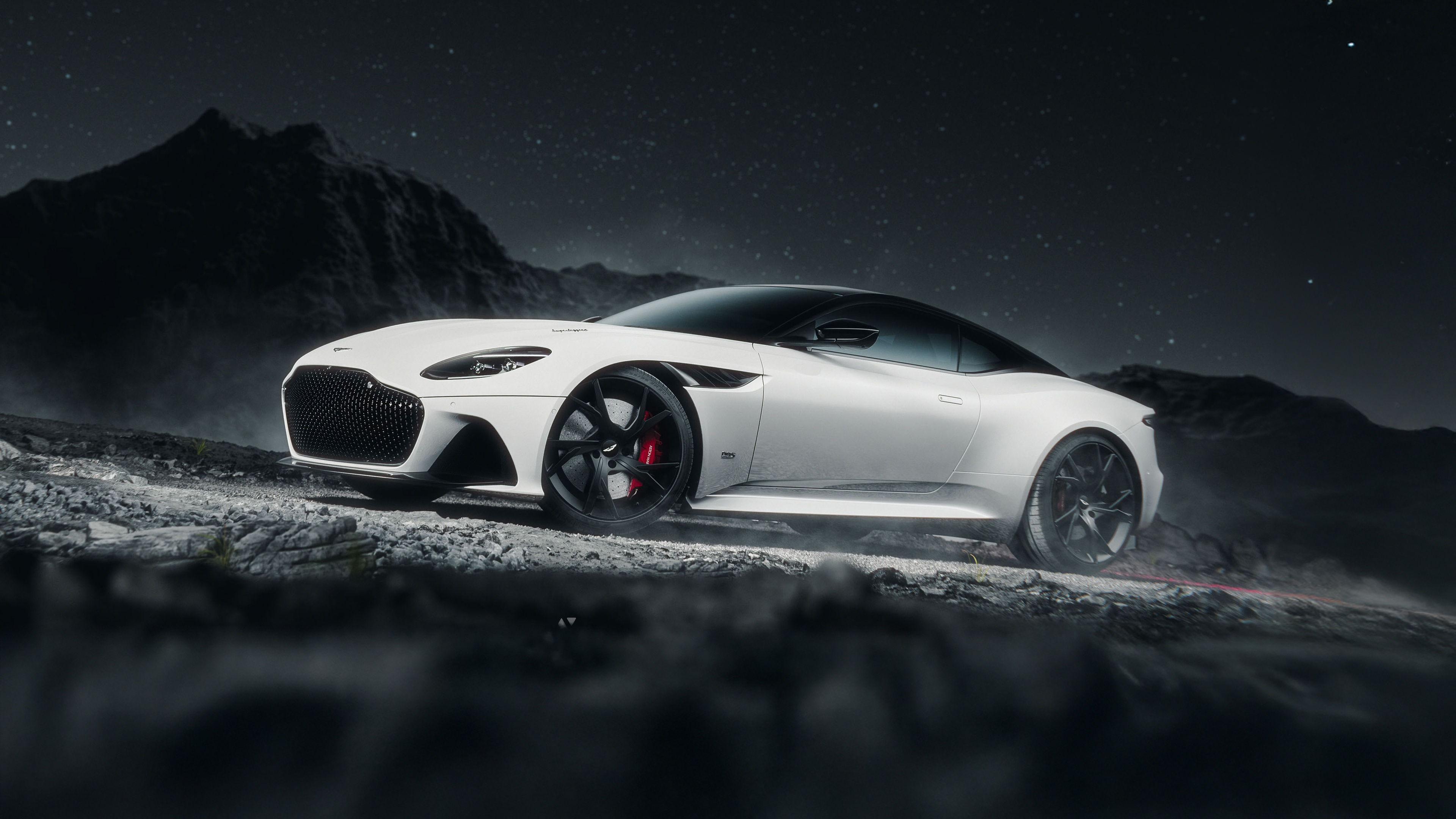 White Aston Martin DBS Superleggera on rocky terrain at night HD Wallpaper