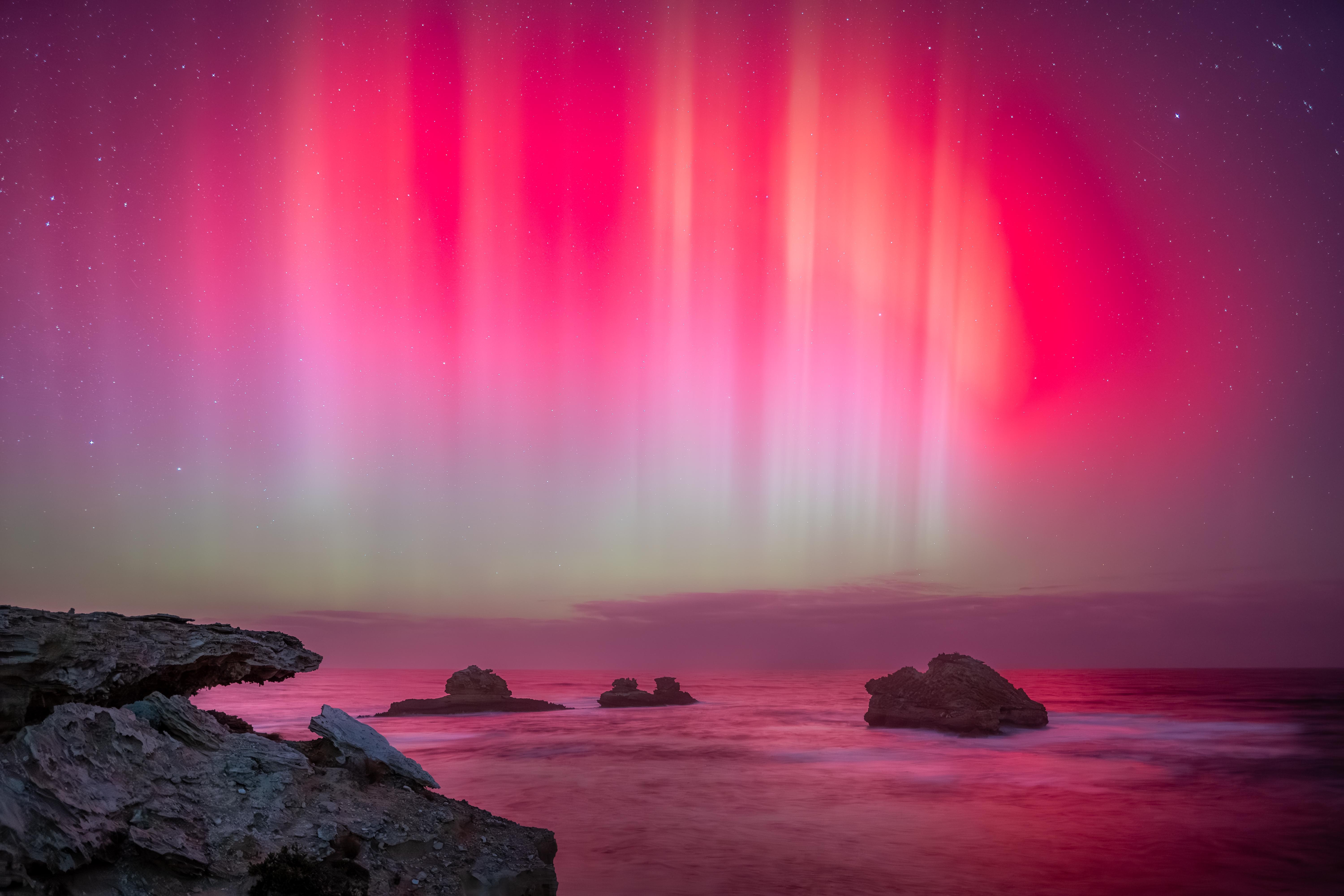 Aurora over the ocean with rocks HD Wallpaper