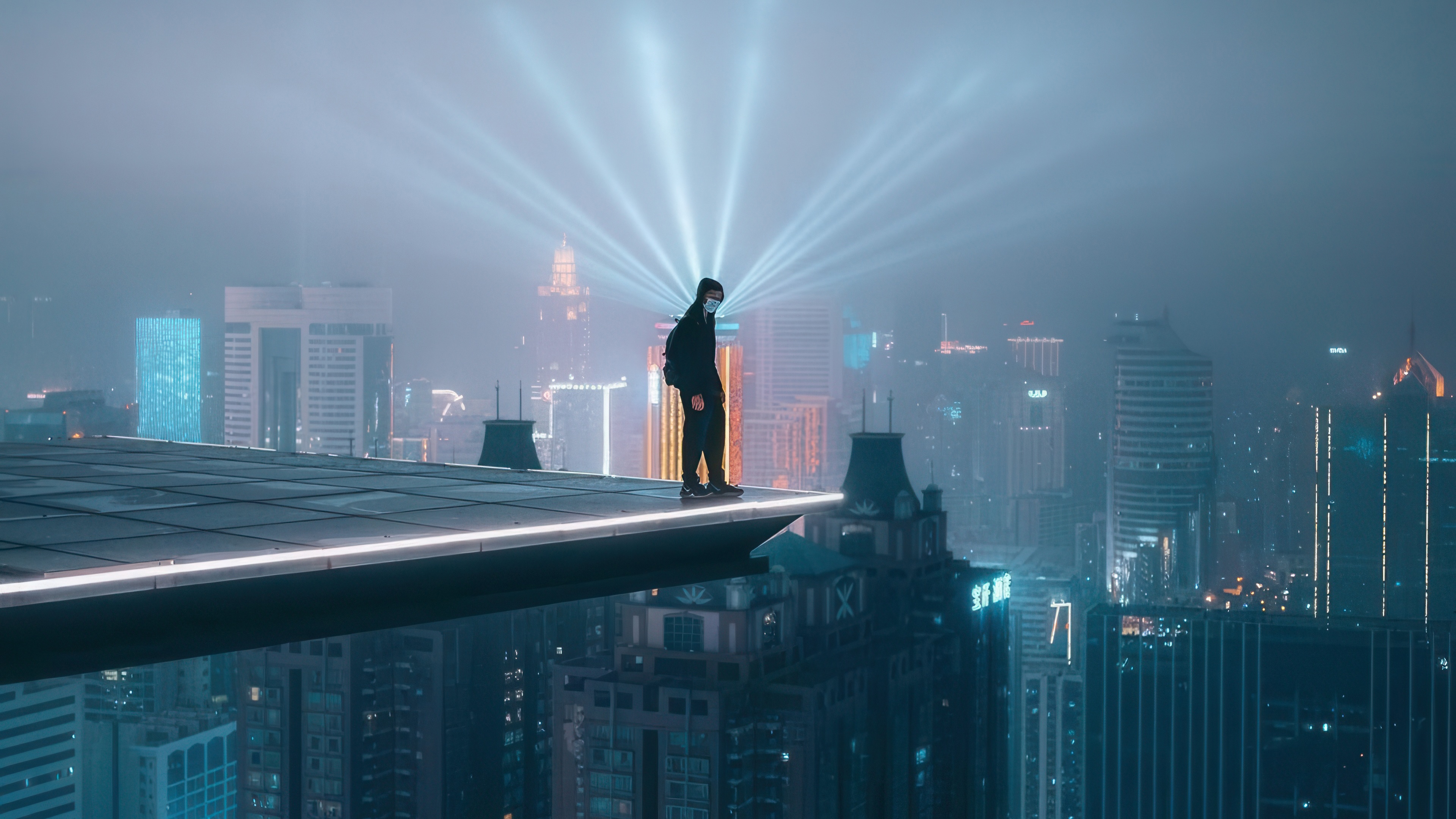 Person on rooftop overlooking city skyline at night HD Wallpaper