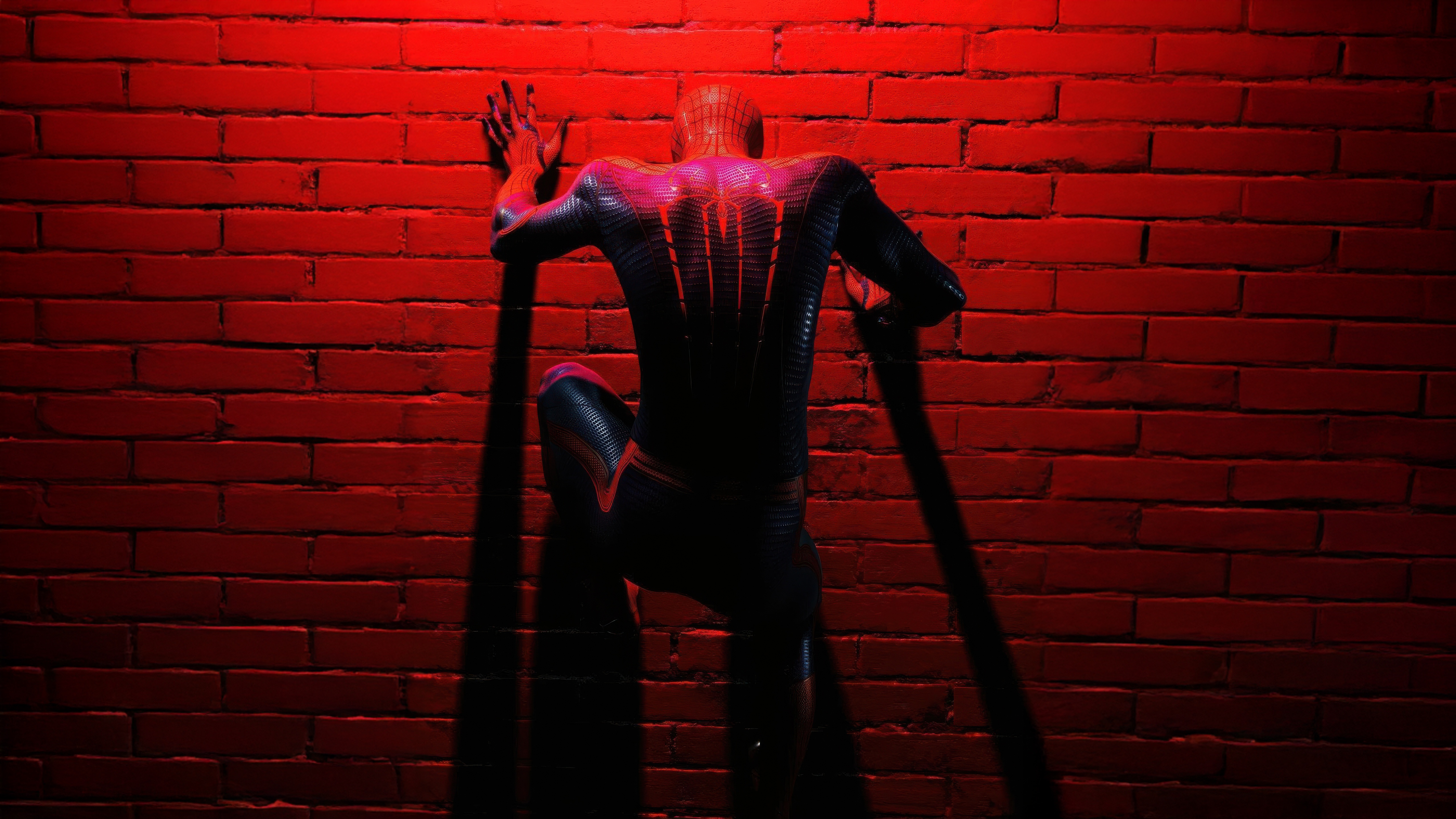 Spider-Man climbs a brick wall under red light HD Wallpaper
