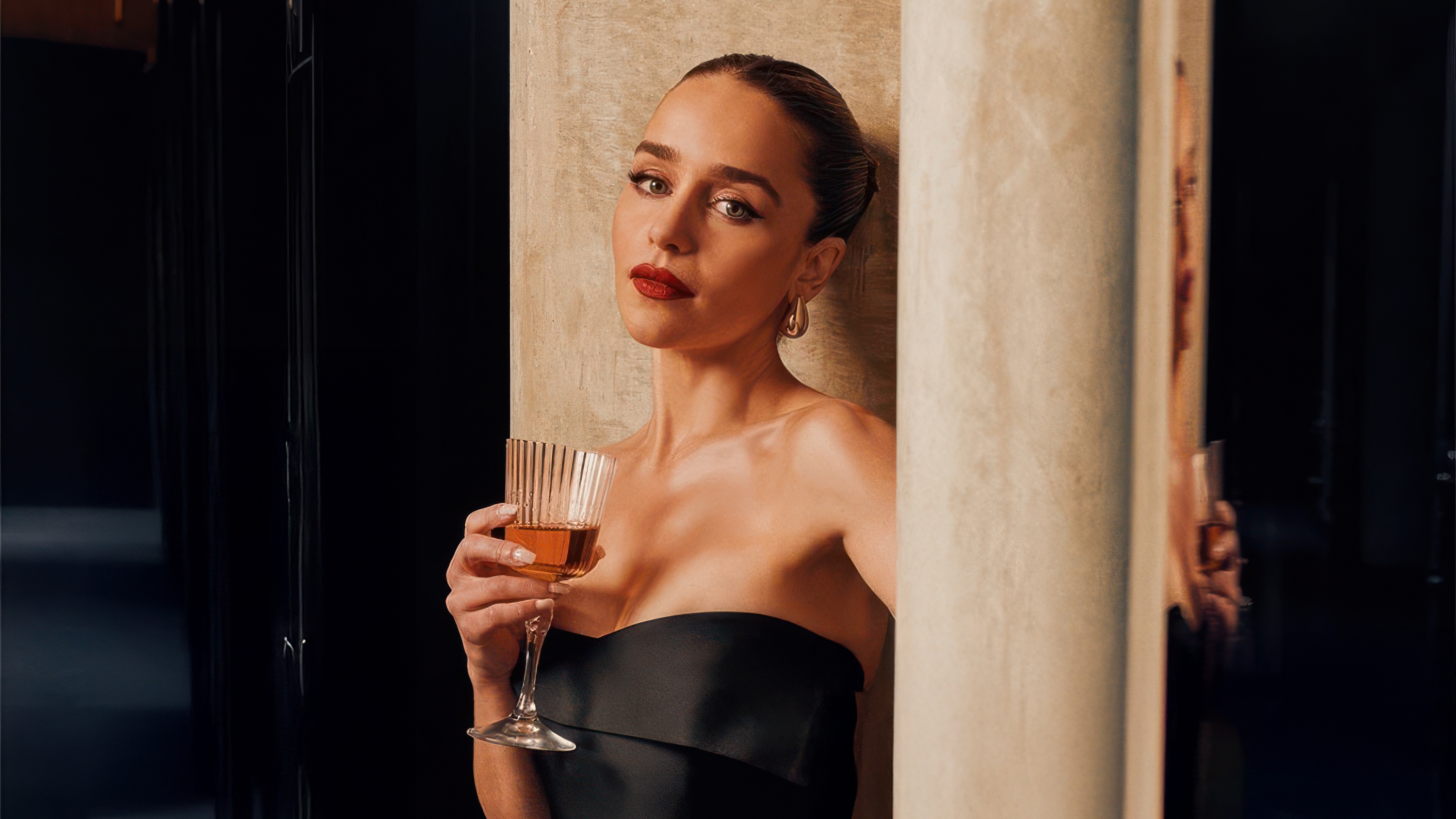 Emilia Clarke holding a glass of amber liquid HD Wallpaper