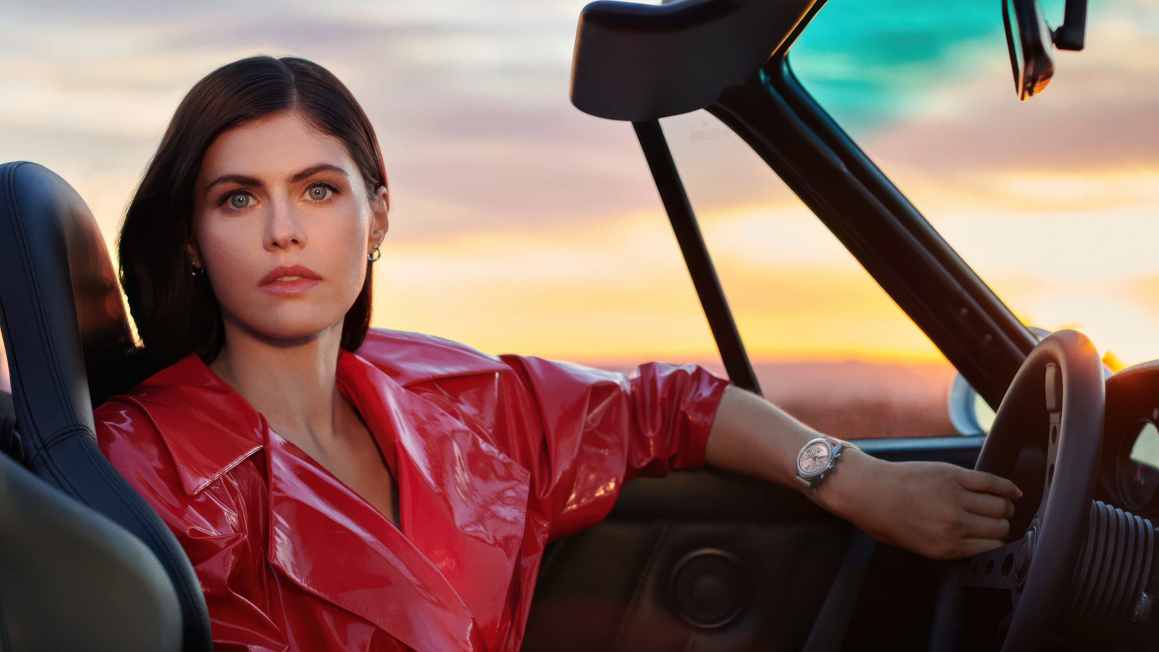 Alexandra Daddario in a red coat driving a car HD Wallpaper