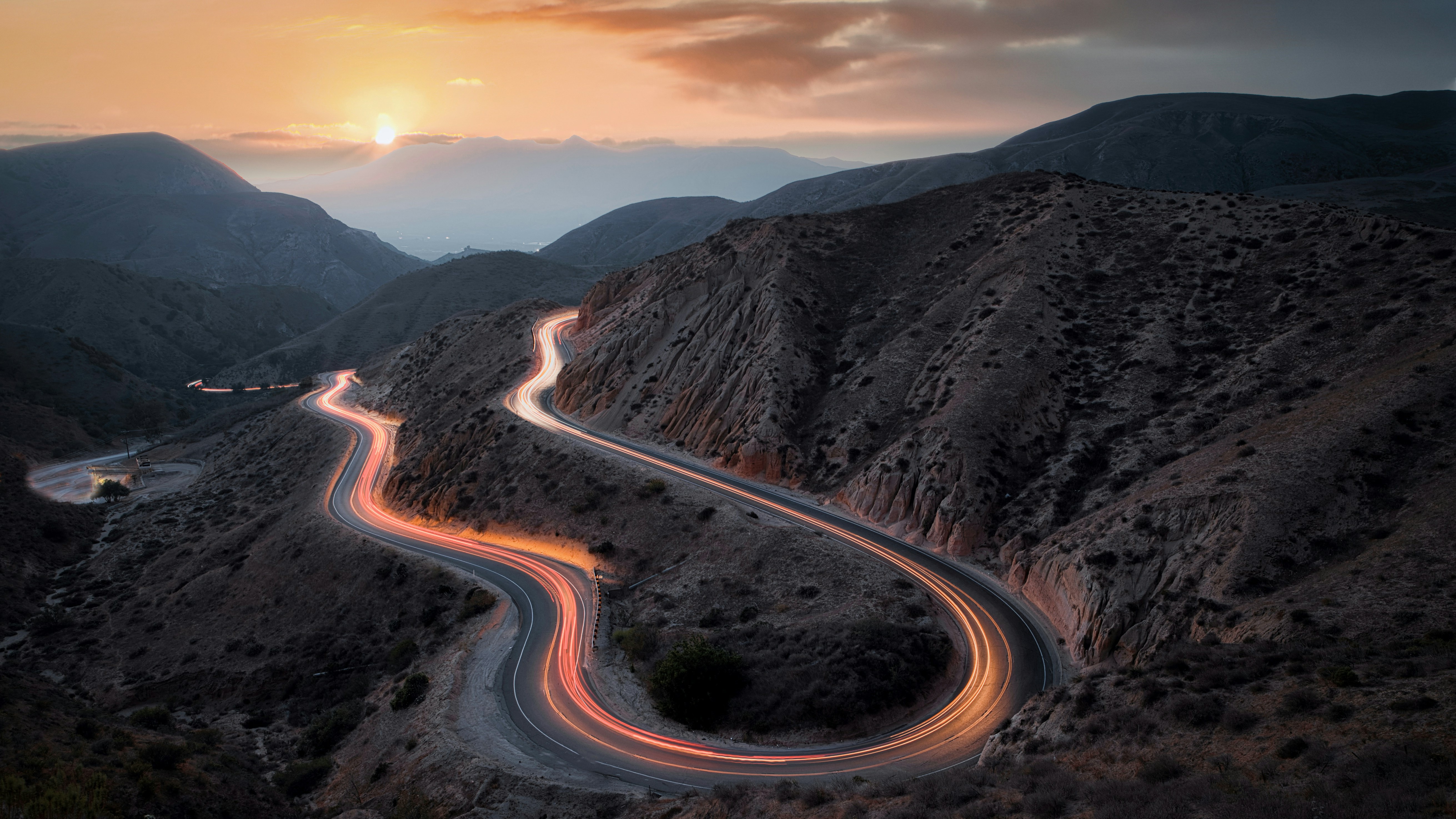 Winding Mountain Road with Light Trails at Sunset HD Wallpaper
