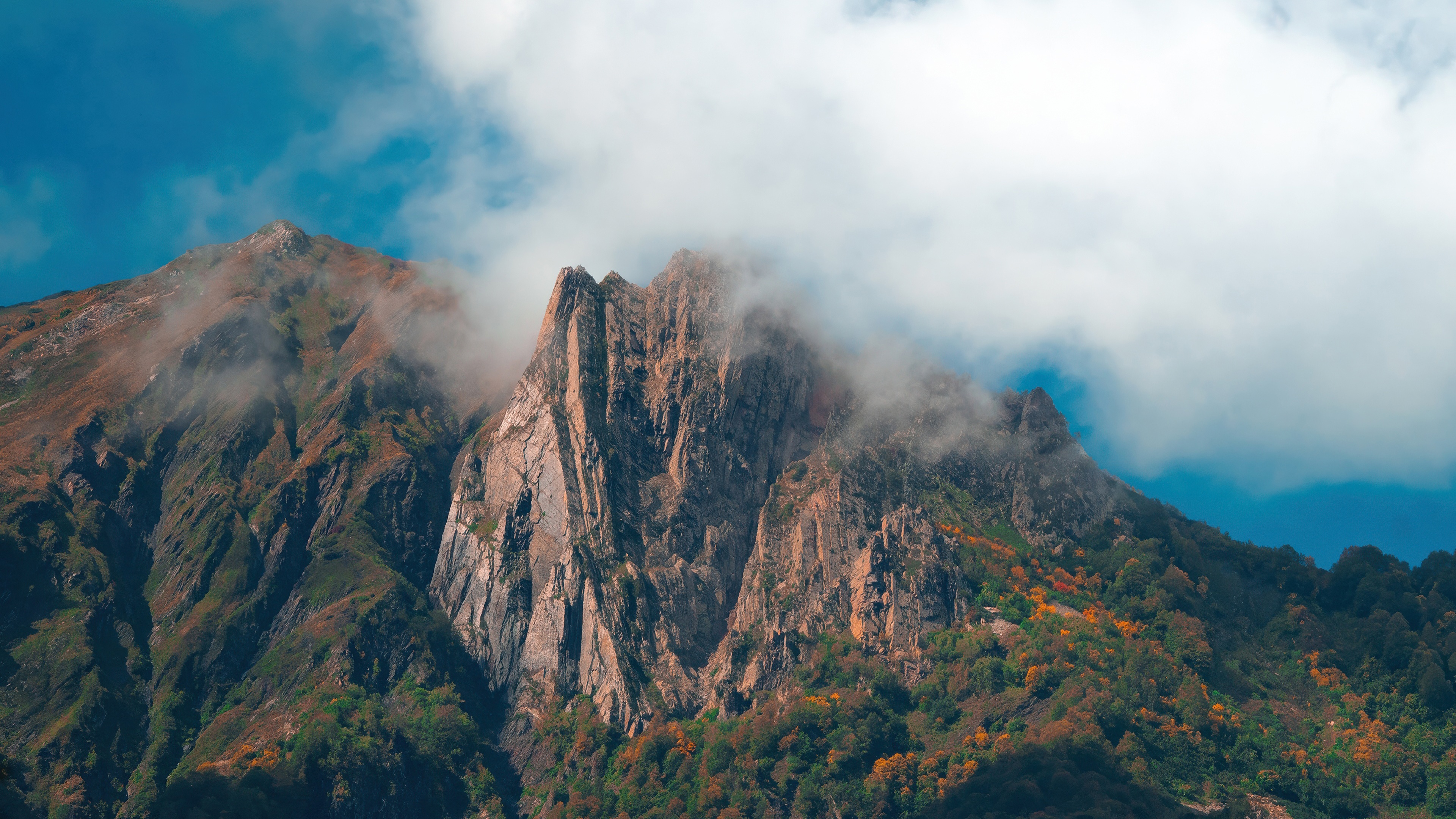 Clouds over rugged mountain peaks HD Wallpaper