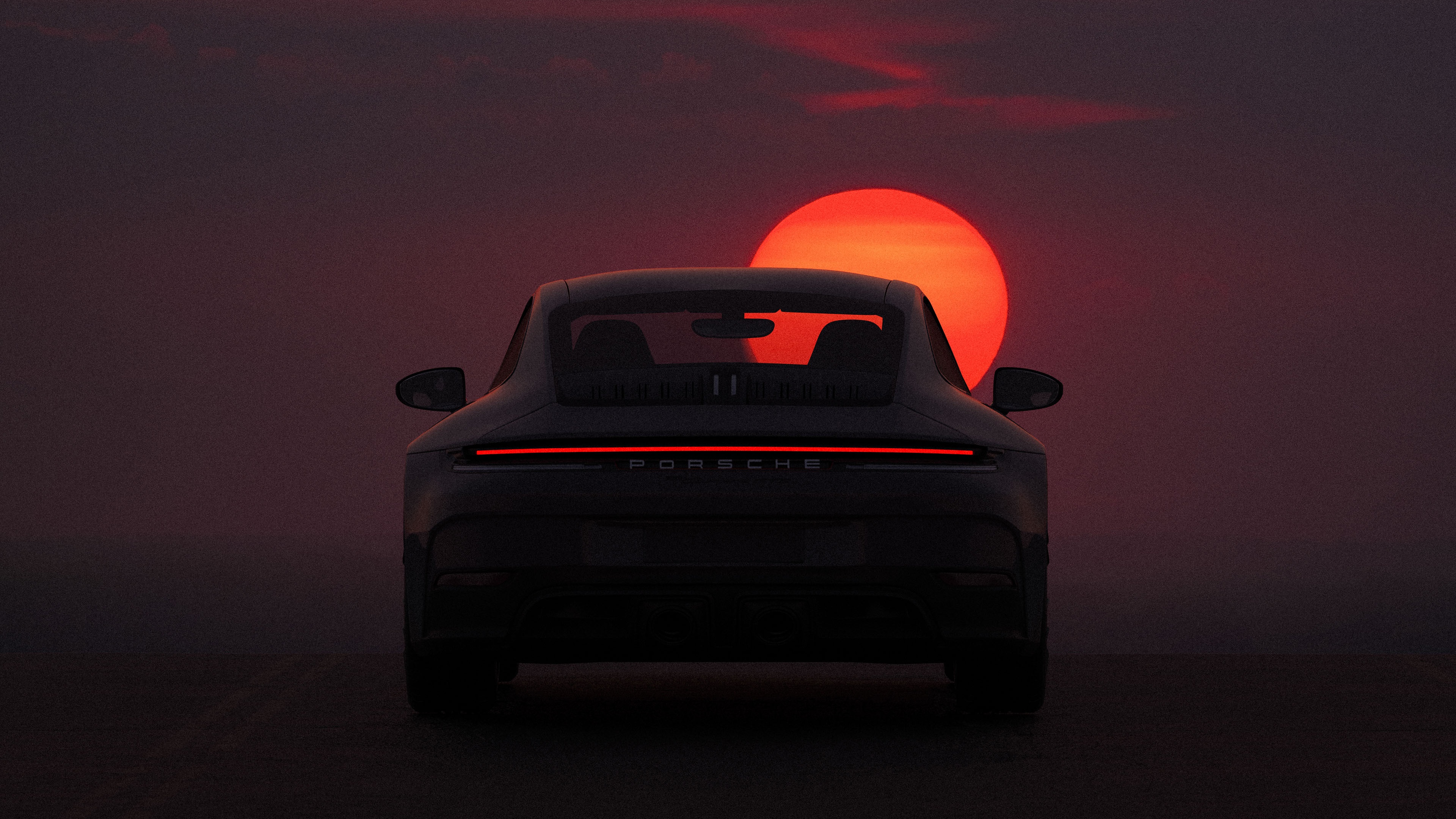 Porsche car silhouetted against a large orange sun HD Wallpaper