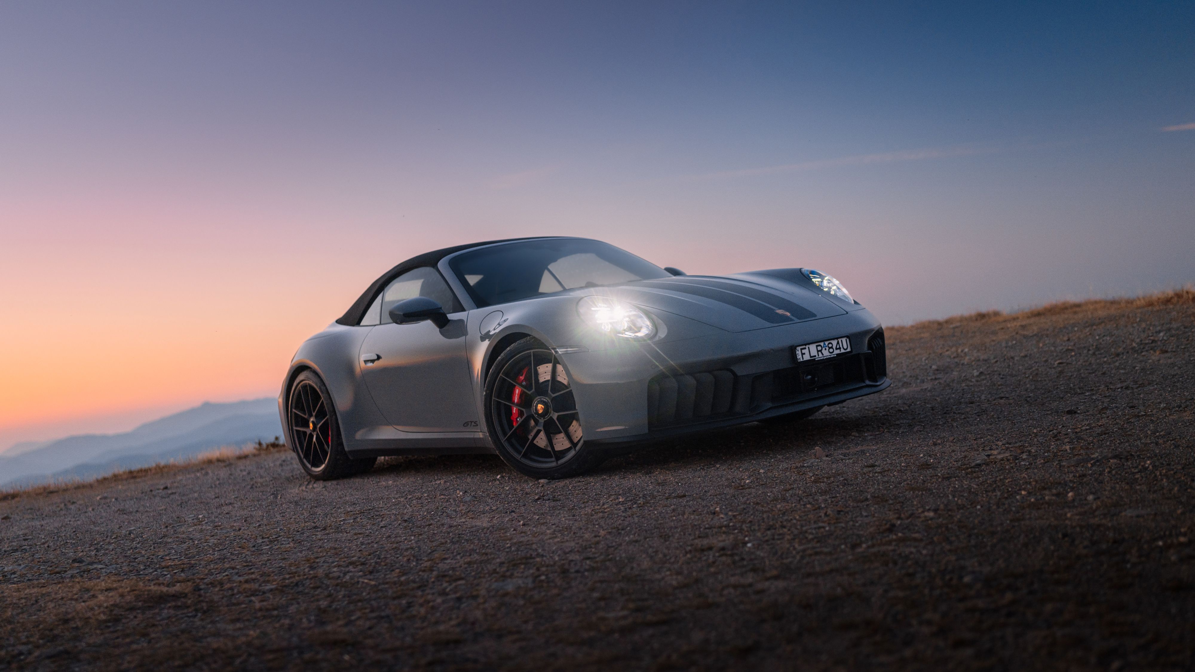 Porsche 911 Carrera GTS Cabriolet on a dirt road HD Wallpaper