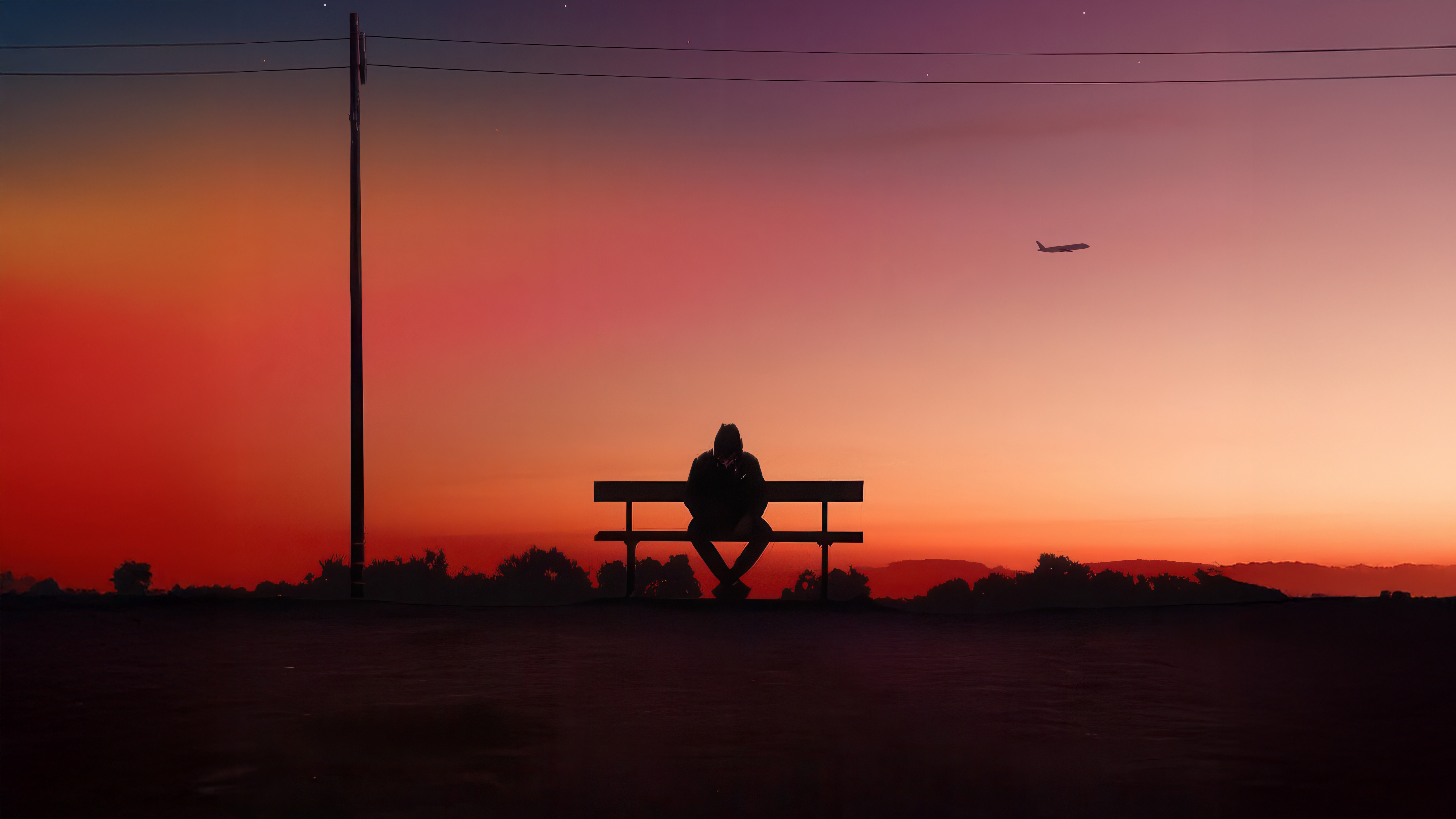Man Sitting on Bench at Dusk with Airplane HD Wallpaper