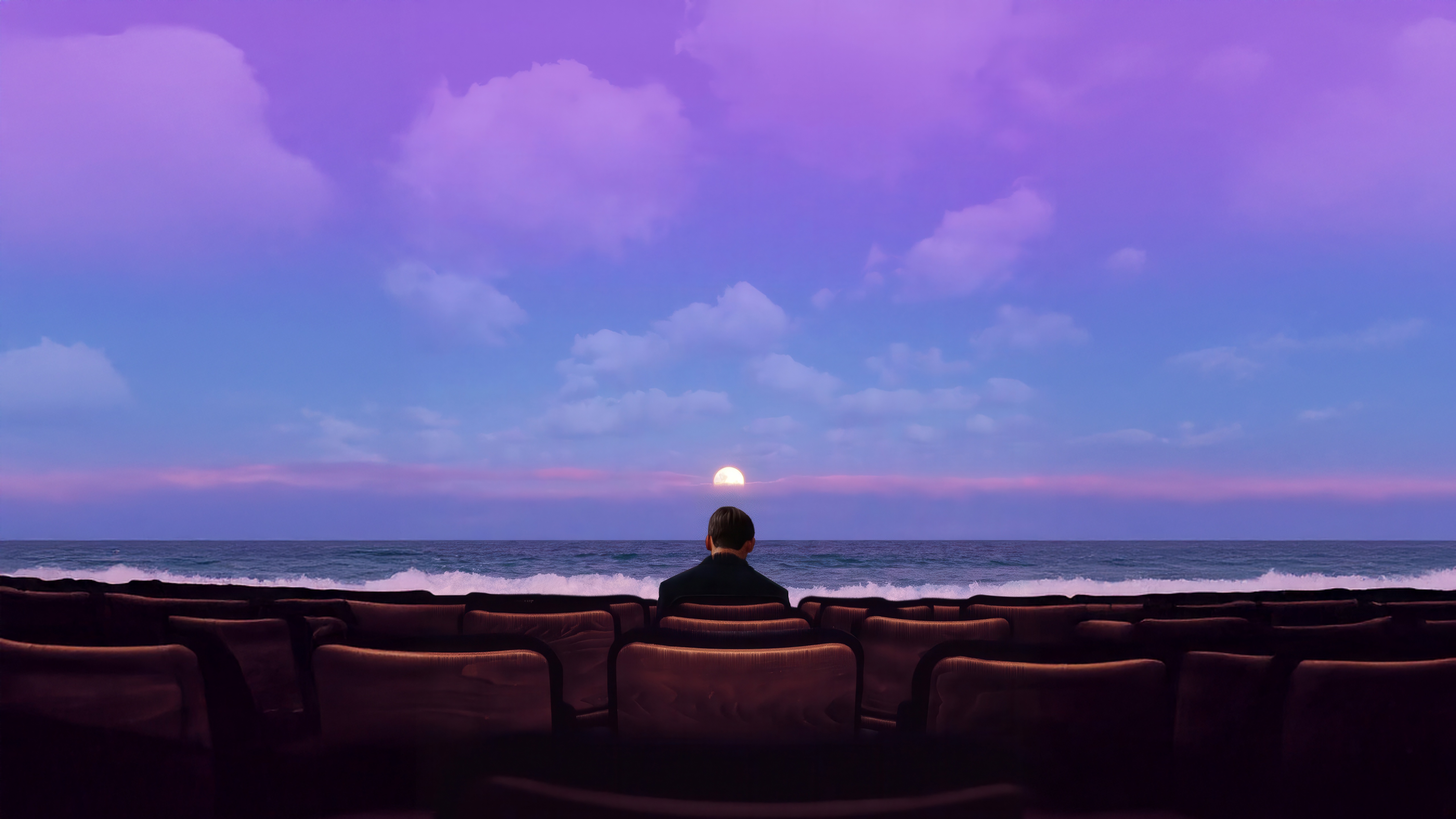 Man watches sunset from theater seats by the ocean HD Wallpaper