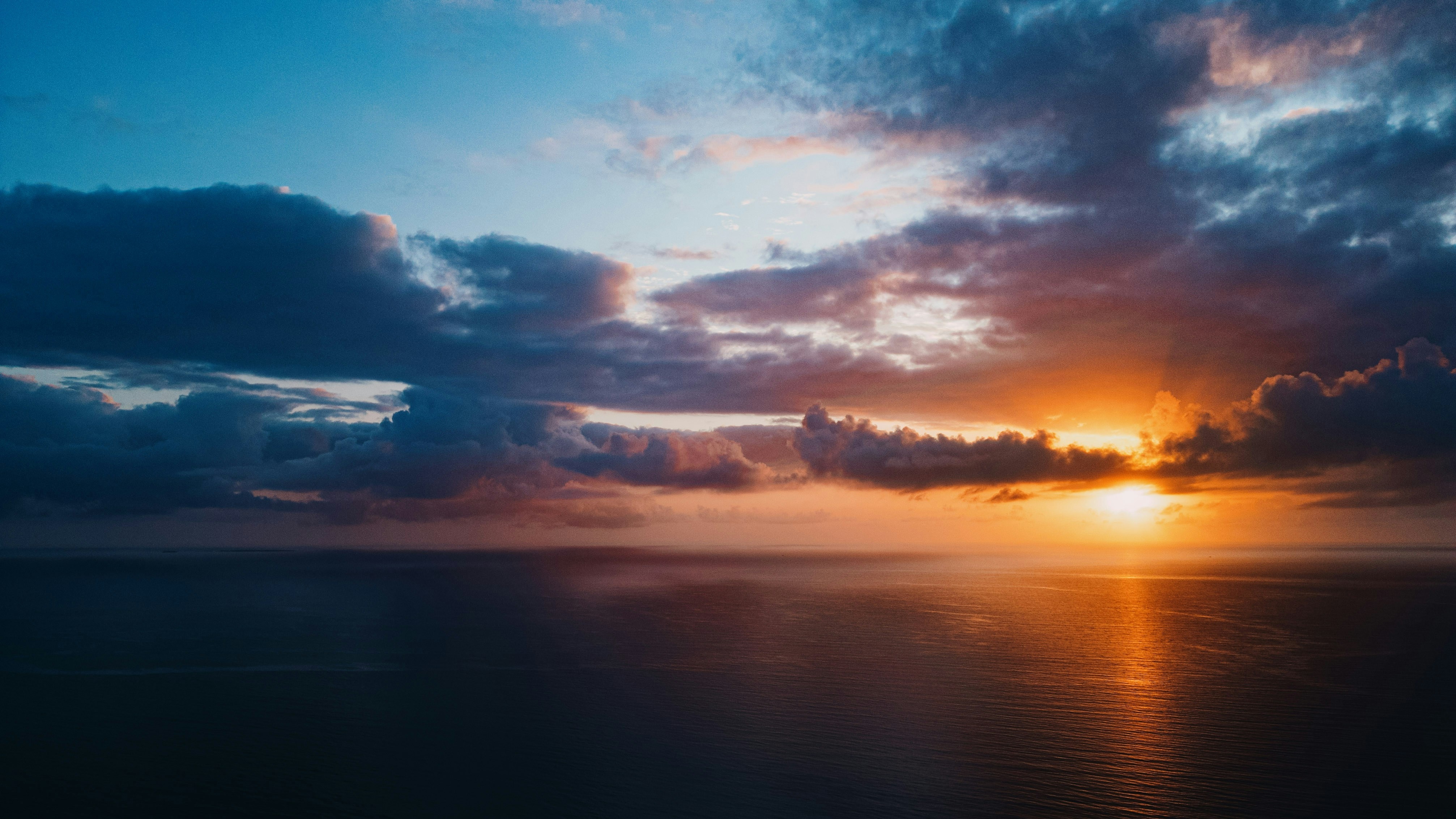 Sunset over the ocean with dramatic clouds HD Wallpaper