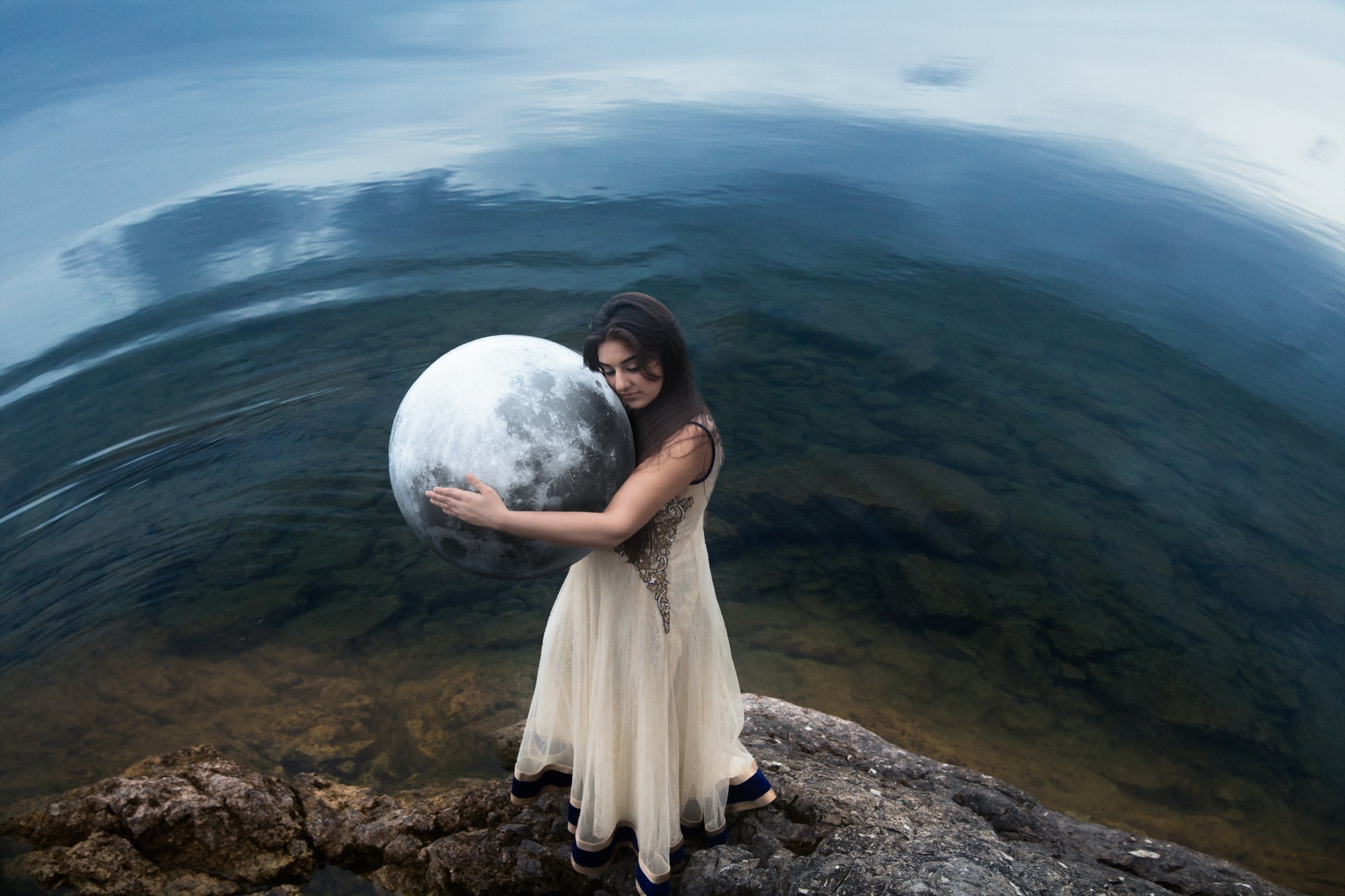 Woman holding a large moon by the water HD Wallpaper