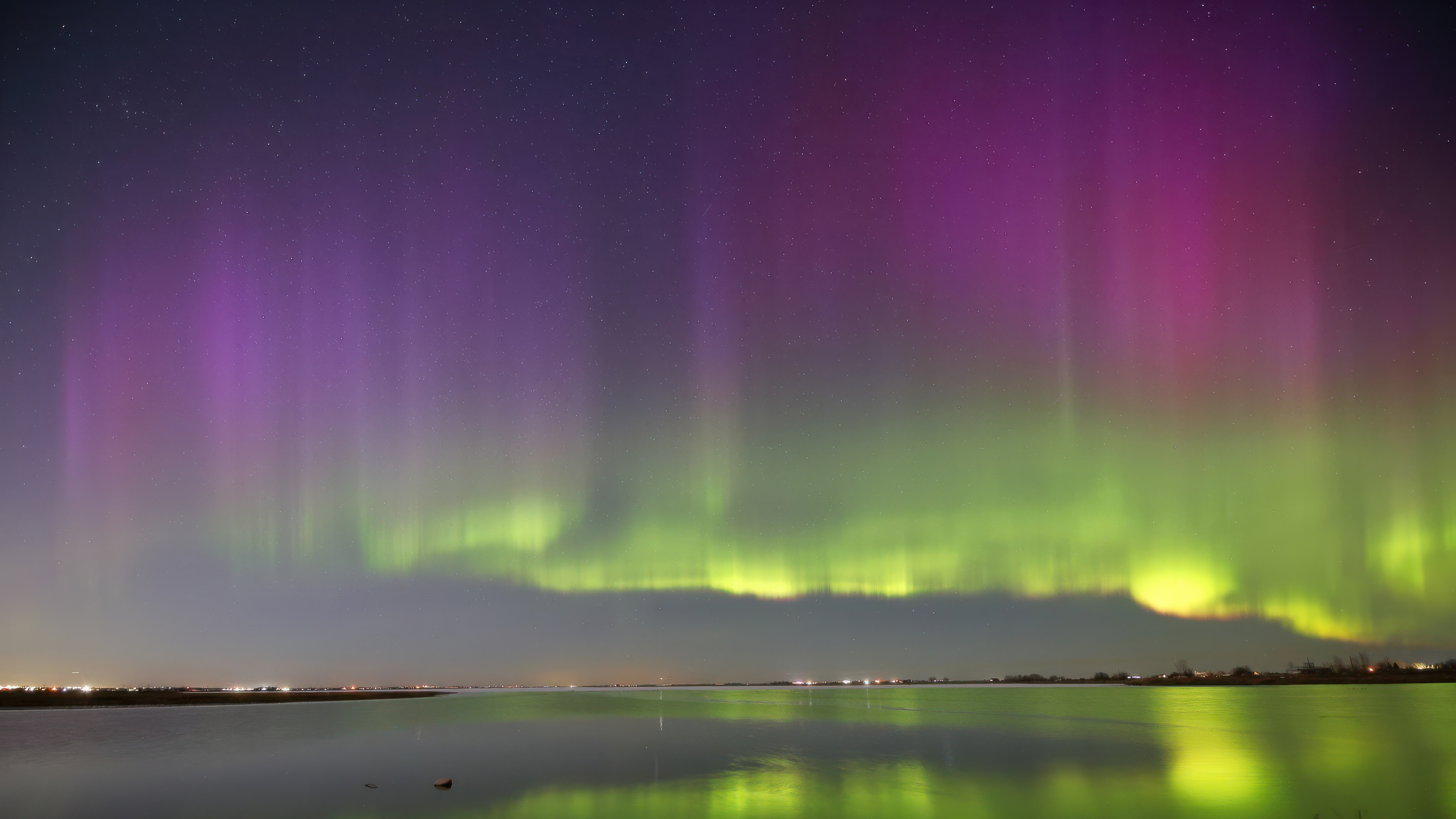 Aurora Borealis over a calm body of water HD Wallpaper