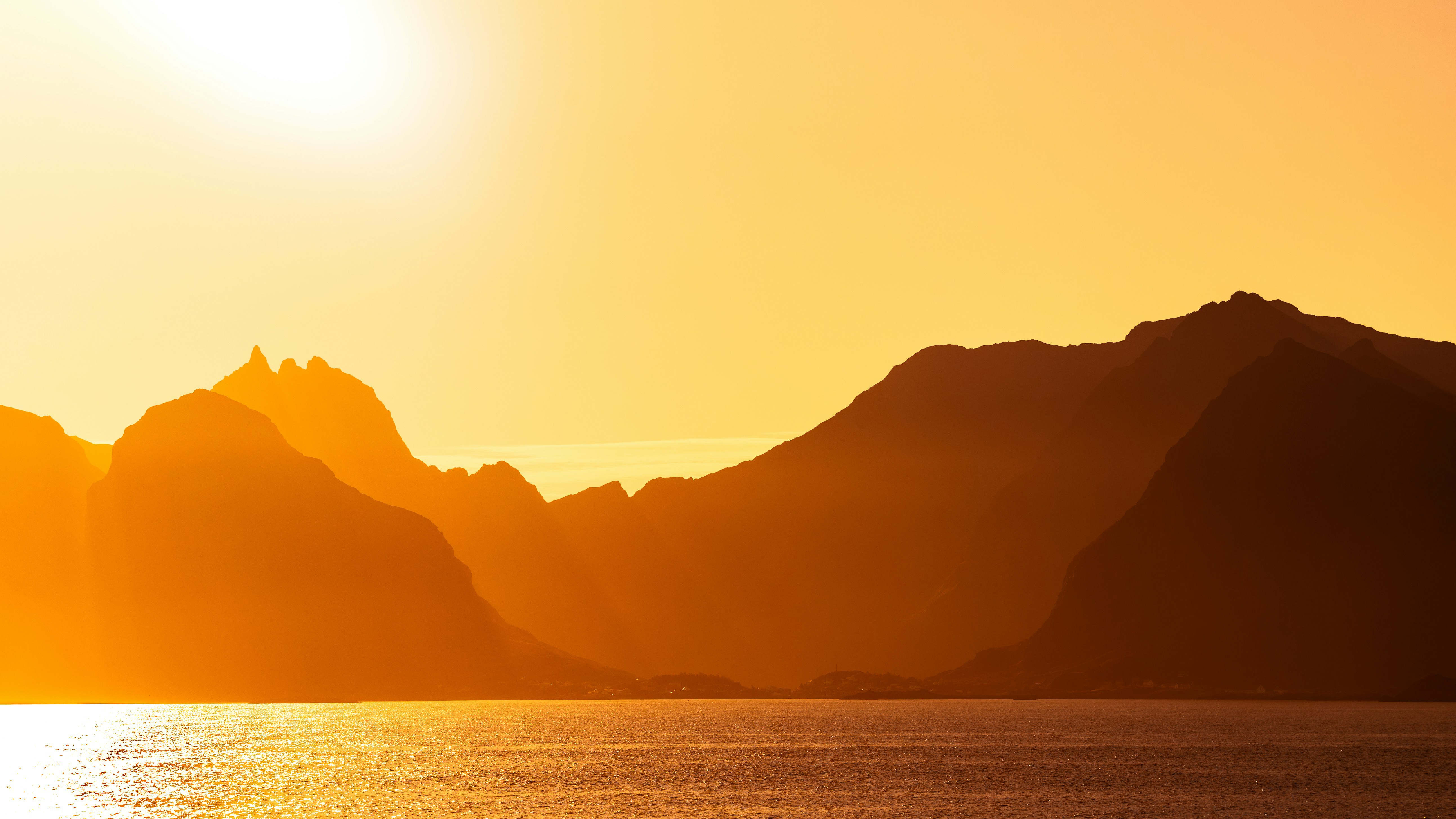 Sunlight over mountains and sea at sunset HD Wallpaper