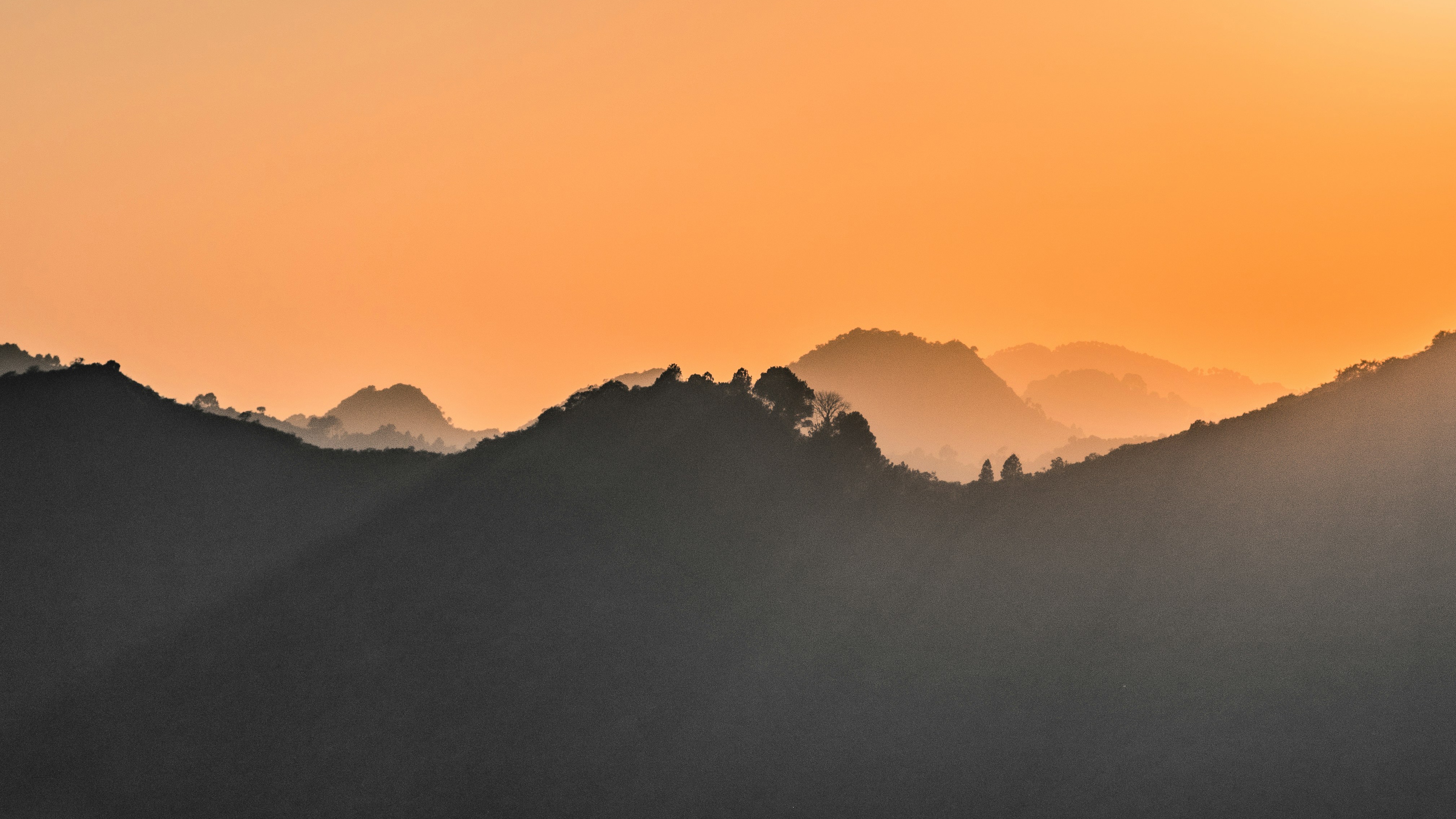 Sunset over a misty mountain range HD Wallpaper