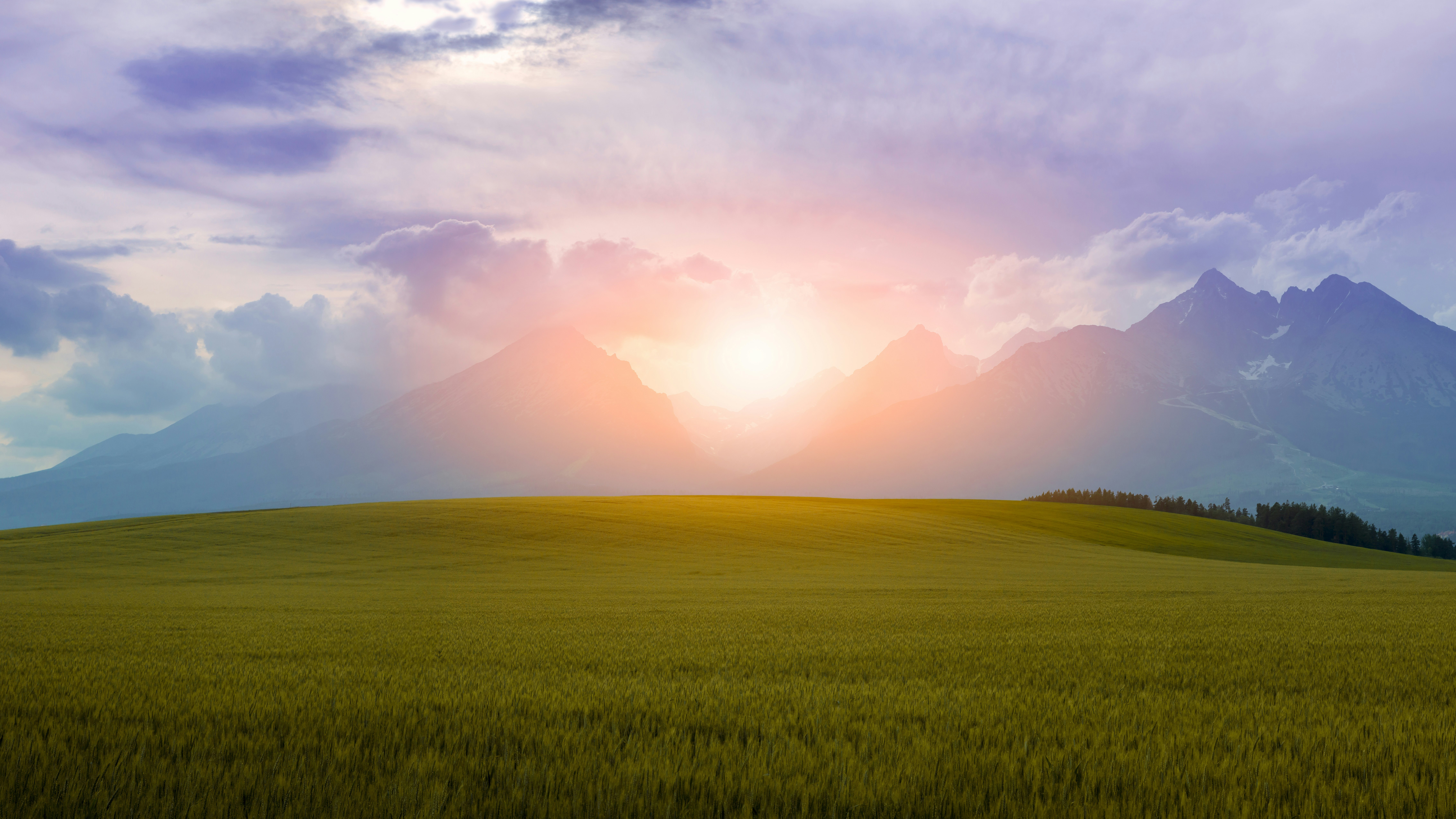 Sunrise over a green field and mountains HD Wallpaper