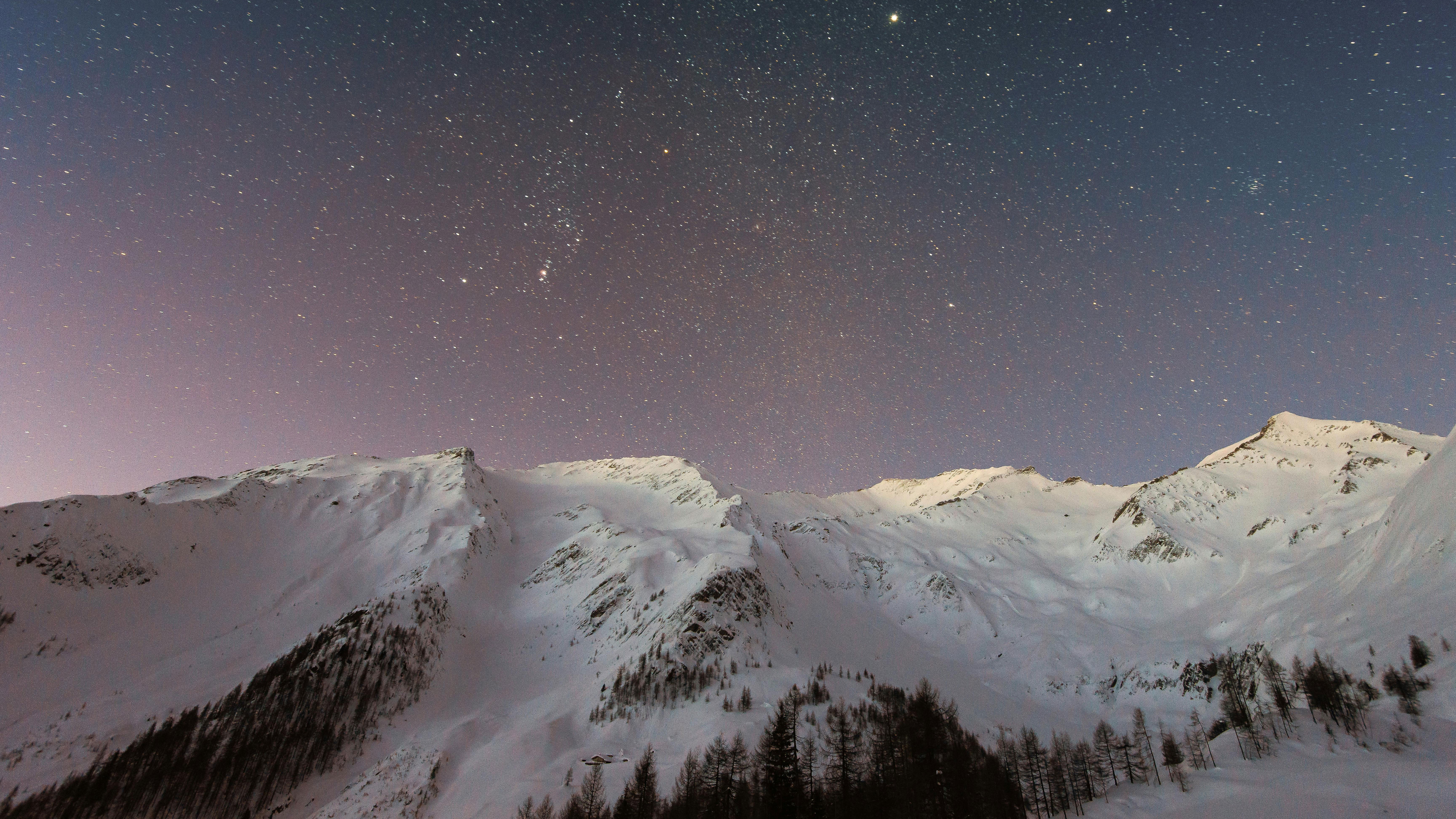 Snowy mountains under a starry night sky HD Wallpaper