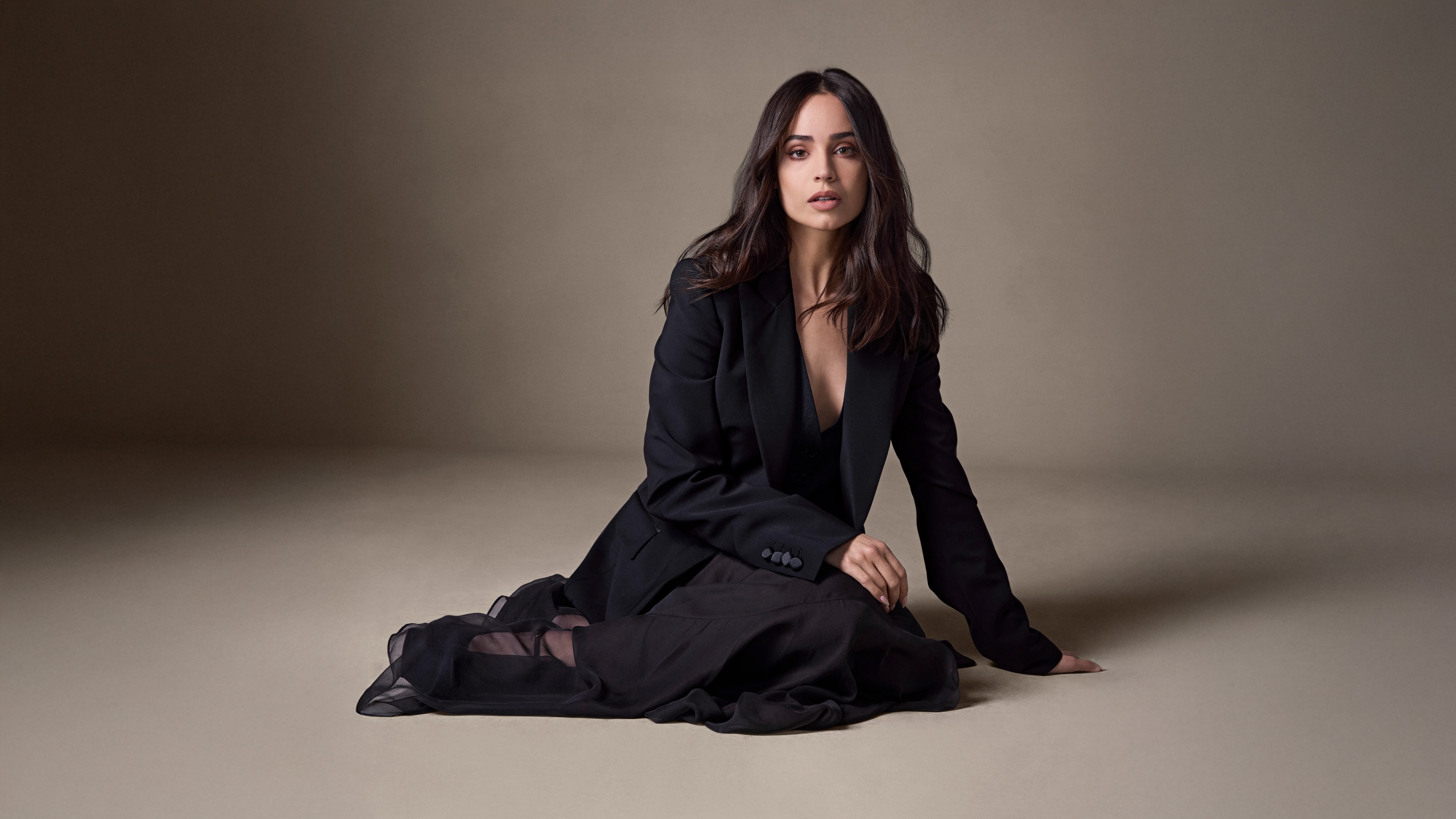 Model in black blazer and dress sitting on floor HD Wallpaper