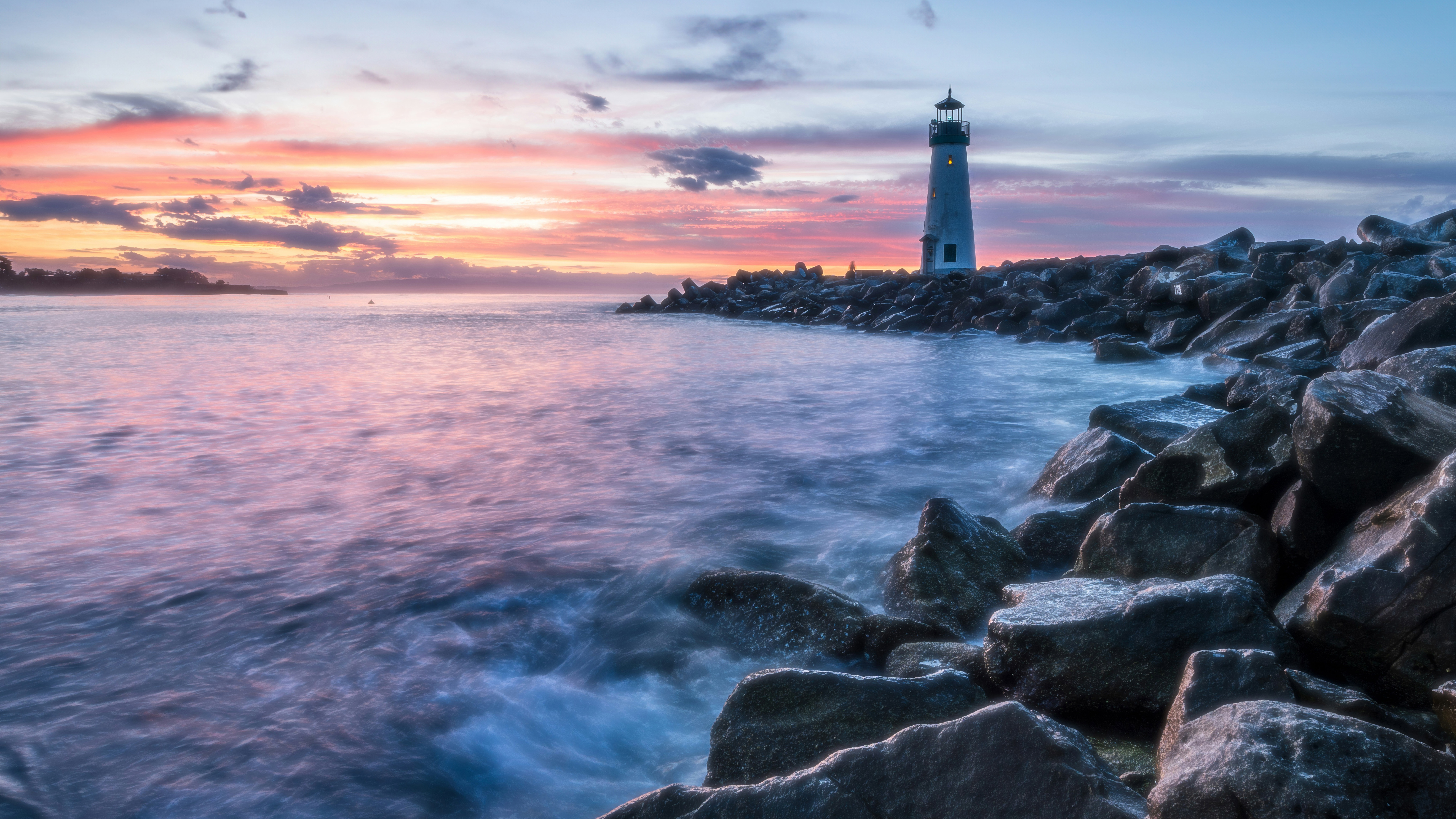 Waves and a lonely lighthouse at sunset HD Wallpaper