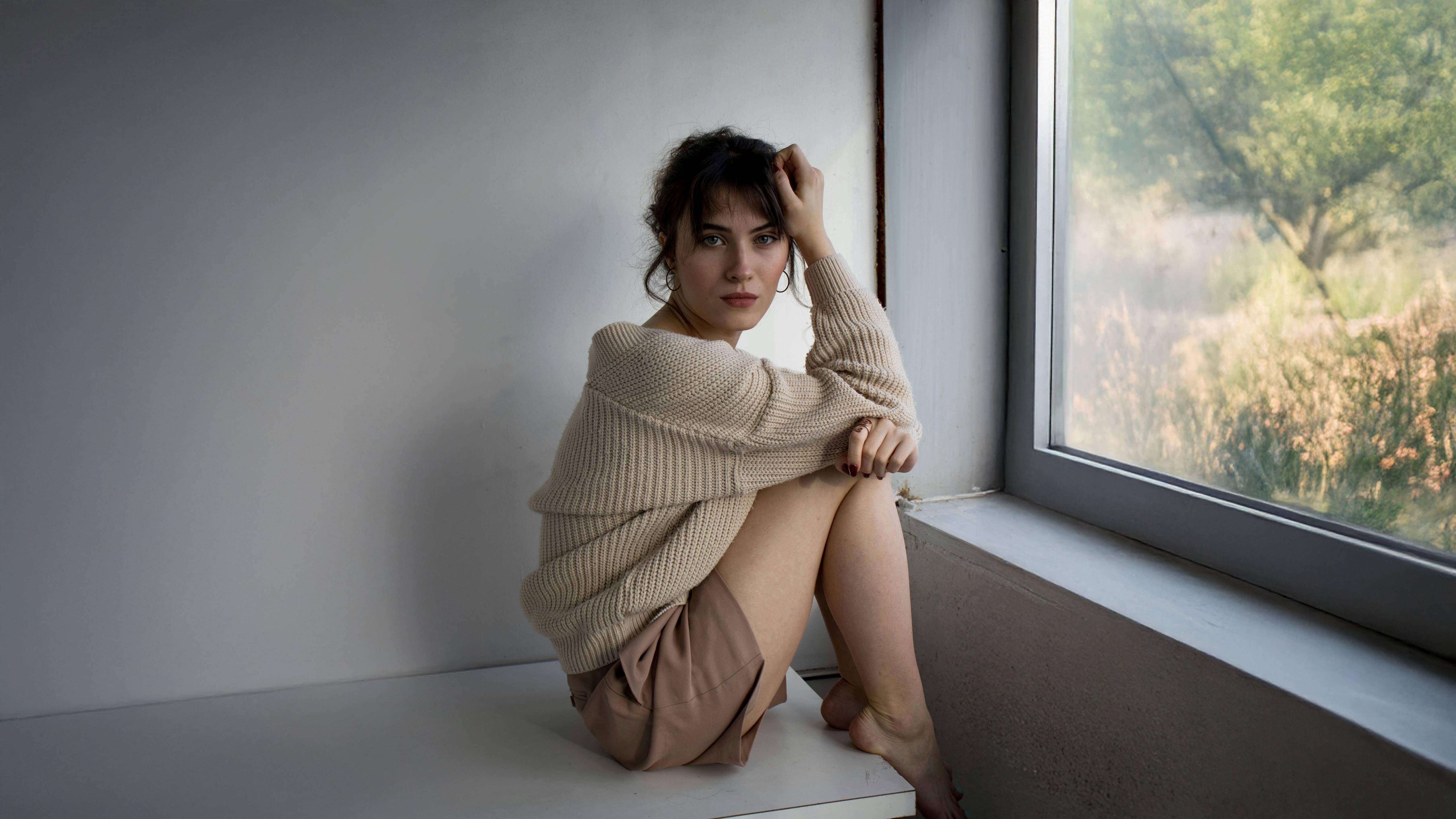 Woman in a cozy sweater sitting by the window HD Wallpaper