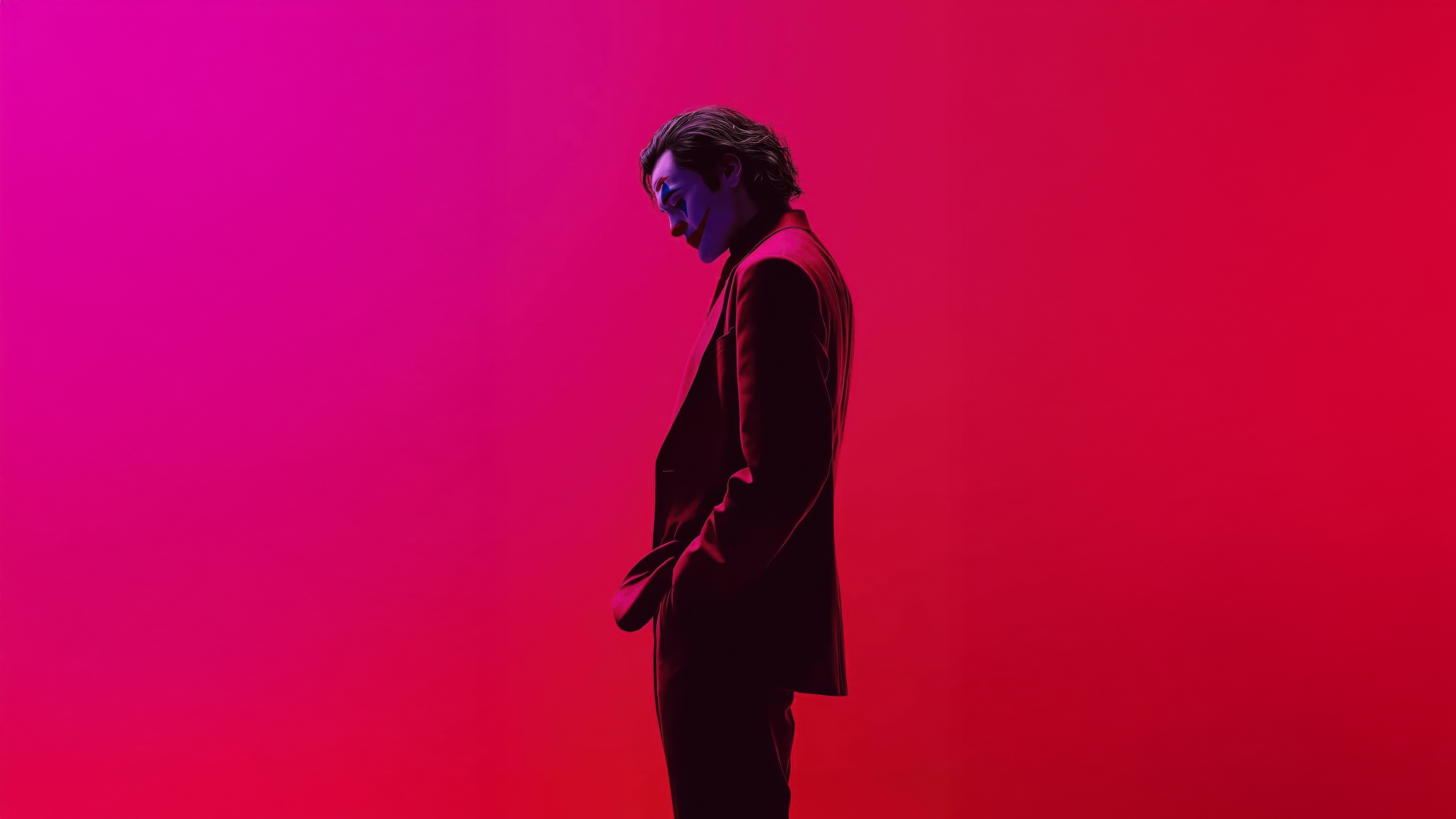 Joker in a purple suit against a pink and red background HD Wallpaper