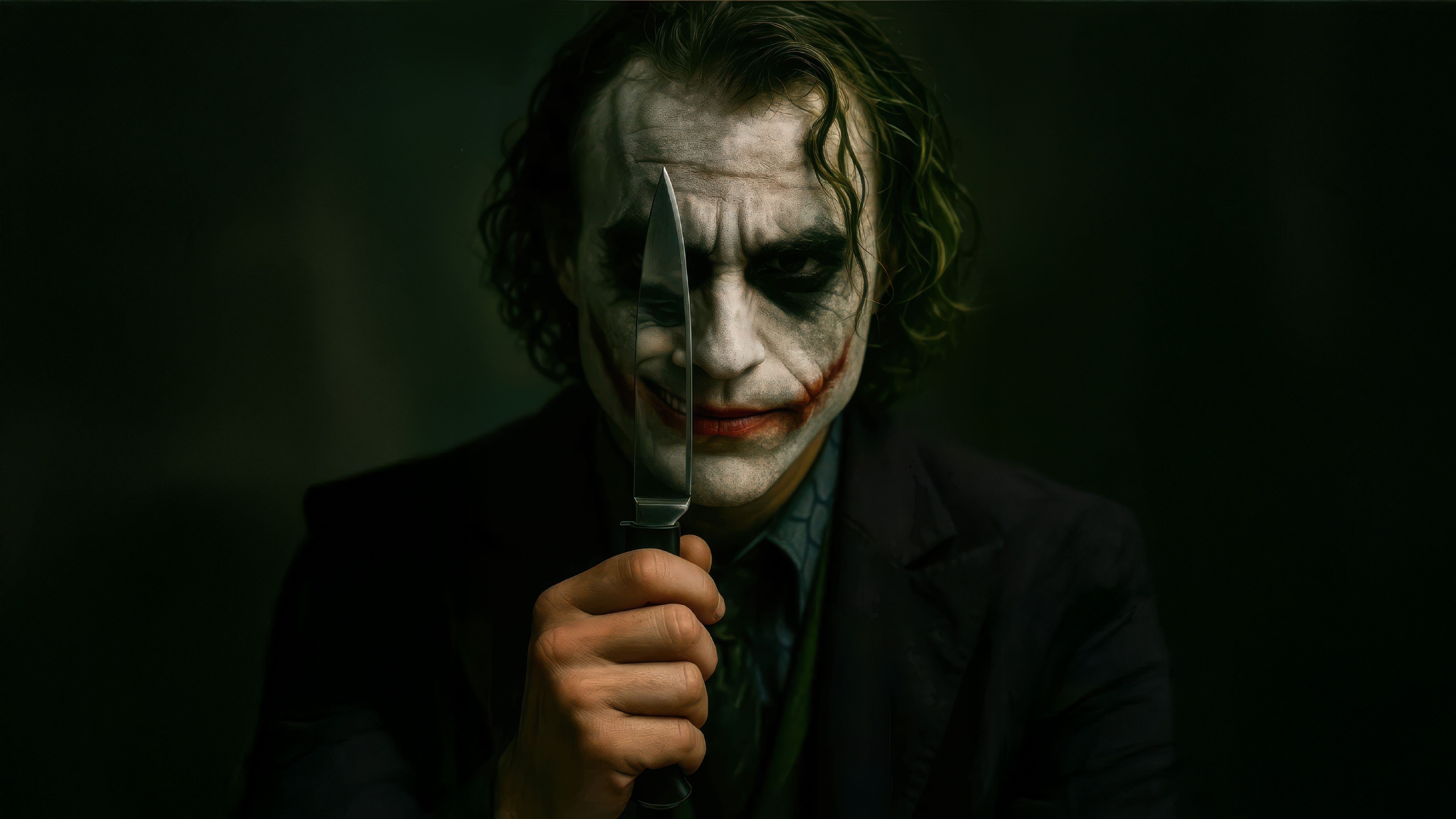 The Joker holds a knife in front of his face HD Wallpaper